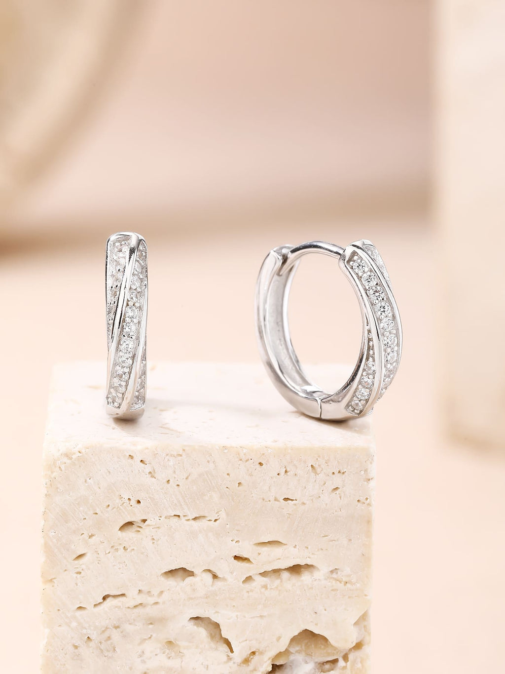 Crossed-band cubic zirconia hoop earrings in hallmarked, rhodium-plated 925 sterling silver – lifestyle view – DRESCHER Jewellery®