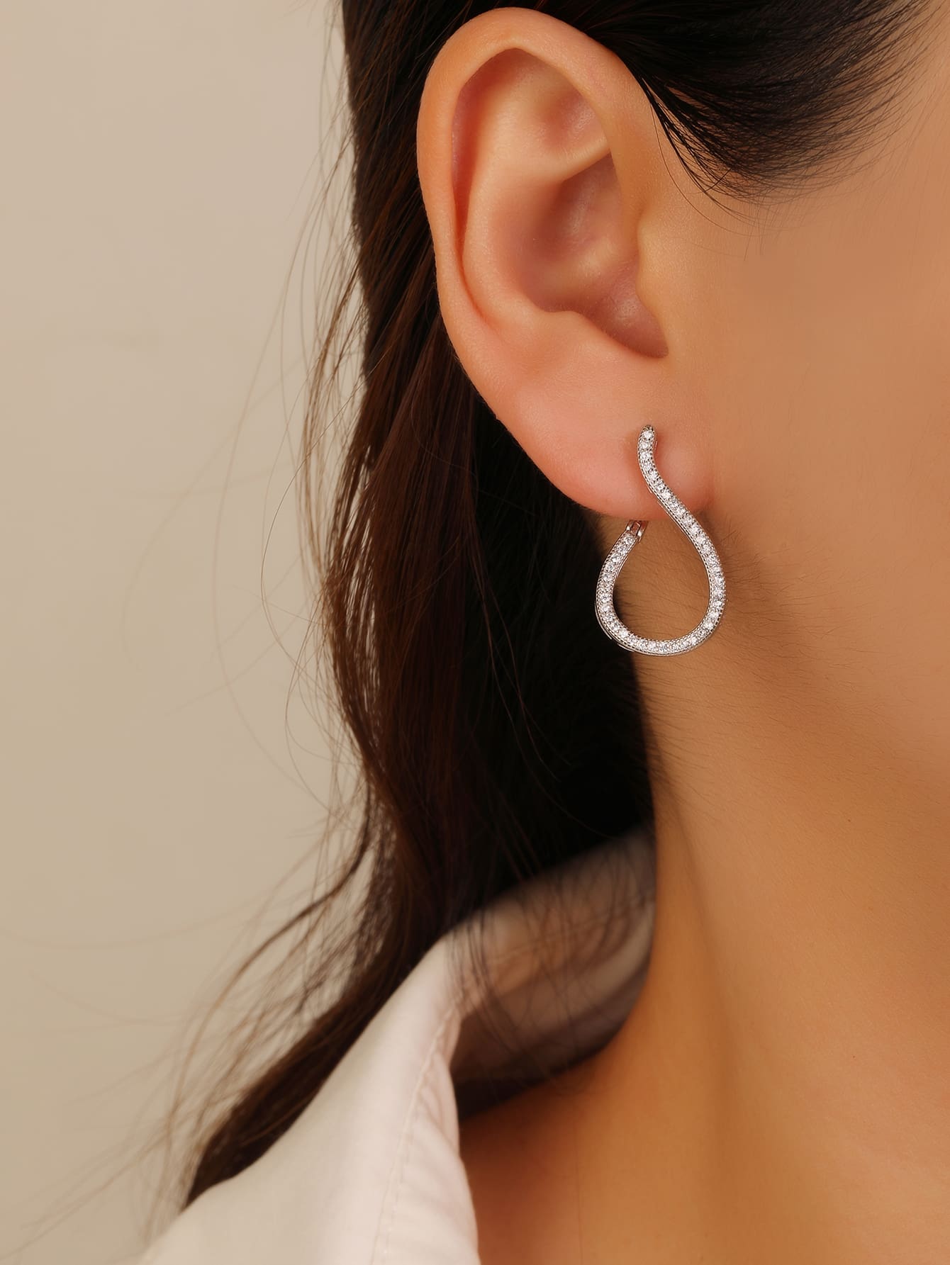 Twisted white cubic zirconia hoop earrings in hallmarked, rhodium-plated 925 sterling silver – worn view – DRESCHER Jewellery®
