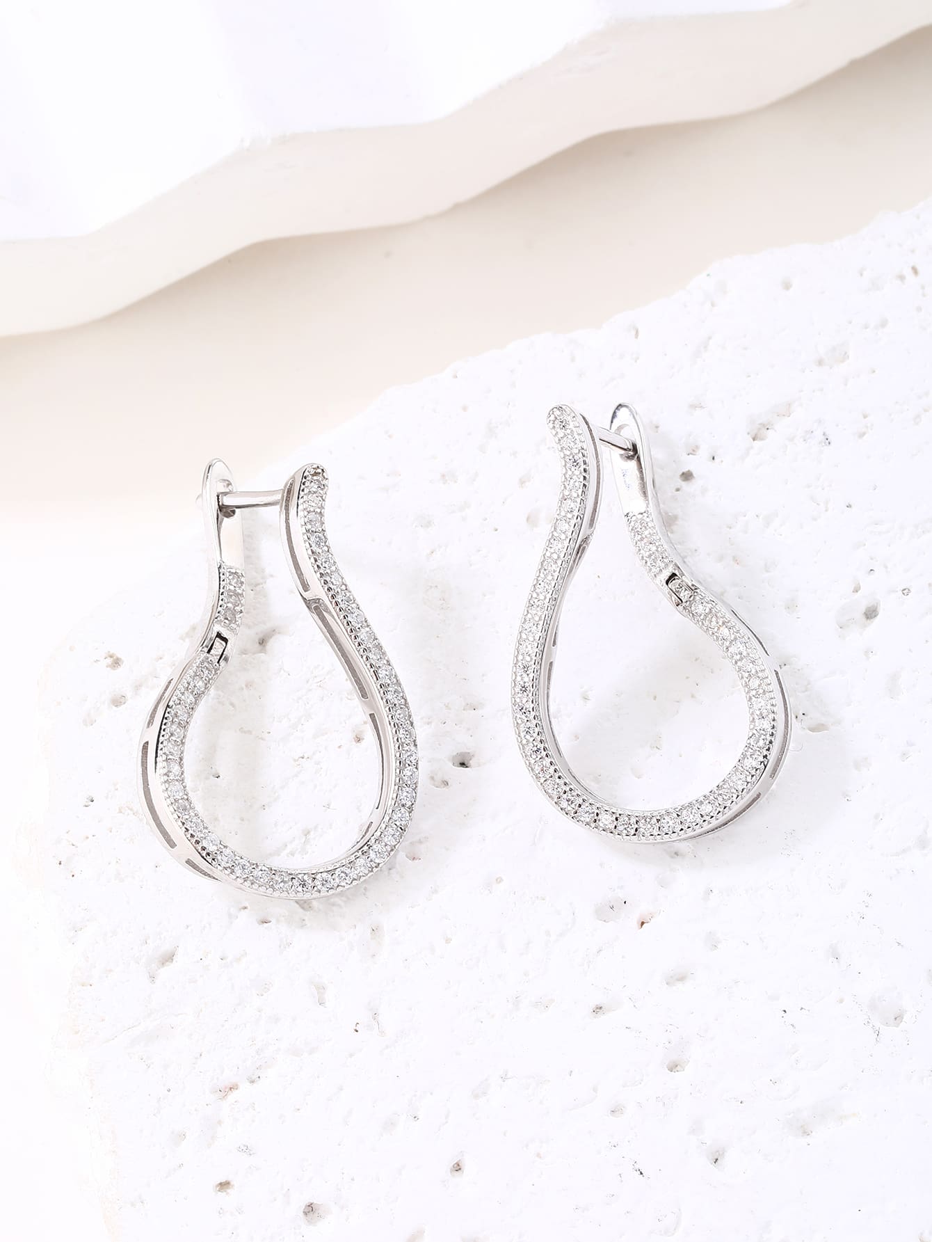 Twisted white cubic zirconia hoop earrings in hallmarked, rhodium-plated 925 sterling silver – display view – DRESCHER Jewellery®