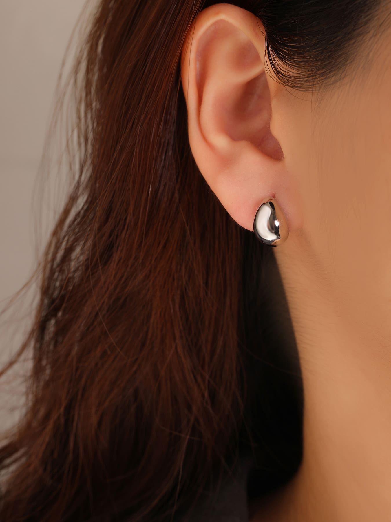 Teardrop-shaped hallmarked, rhodium-plated 925 sterling silver stud earrings – worn view – DRESCHER Jewellery®