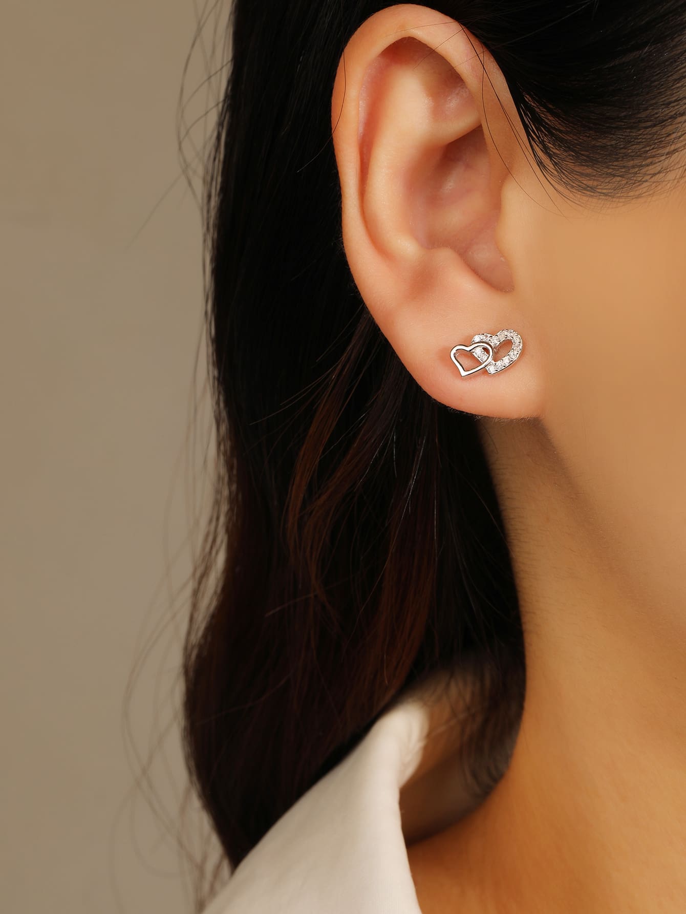 white cubic zirconia double-heart stud earrings in hallmarked, rhodium-plated 925 sterling silver – worn view – DRESCHER Jewellery®