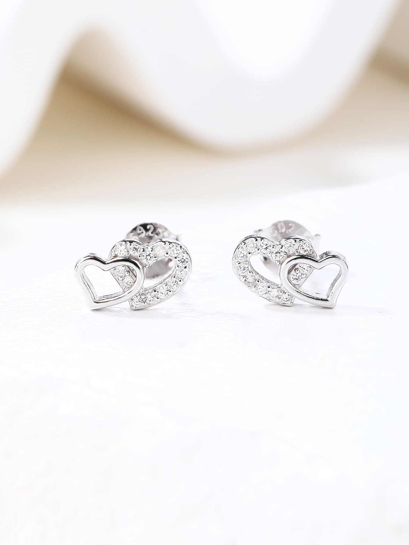 white cubic zirconia double-heart stud earrings in hallmarked, rhodium-plated 925 sterling silver – display view – DRESCHER Jewellery®