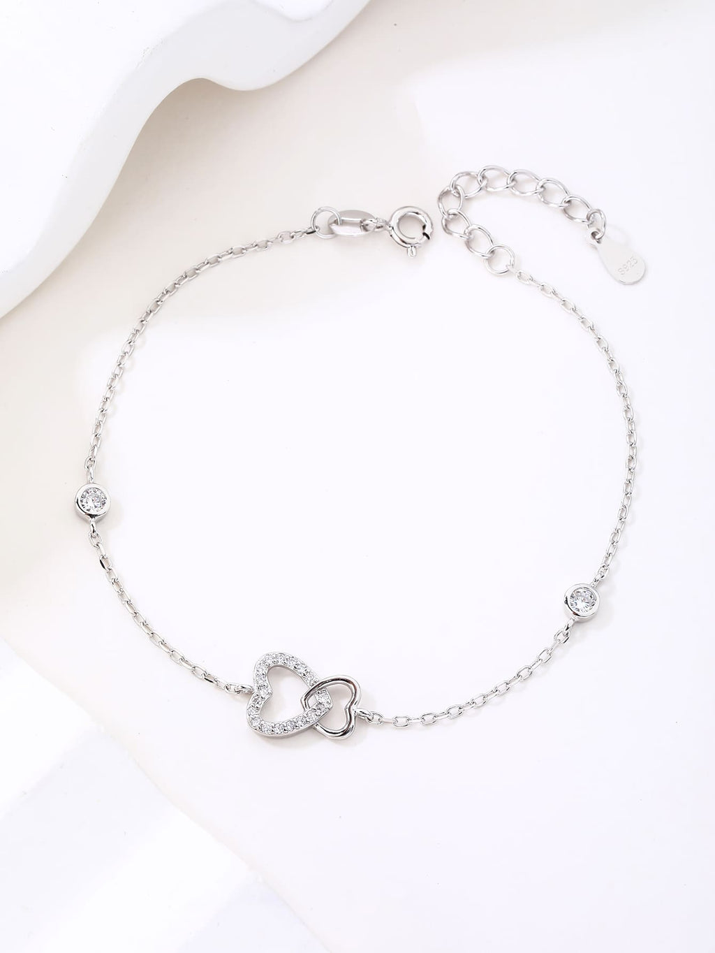 Double heart motif bracelet with cubic zirconia stones in hallmarked, rhodium-plated 925 sterling silver – lifestyle view – DRESCHER Jewellery®