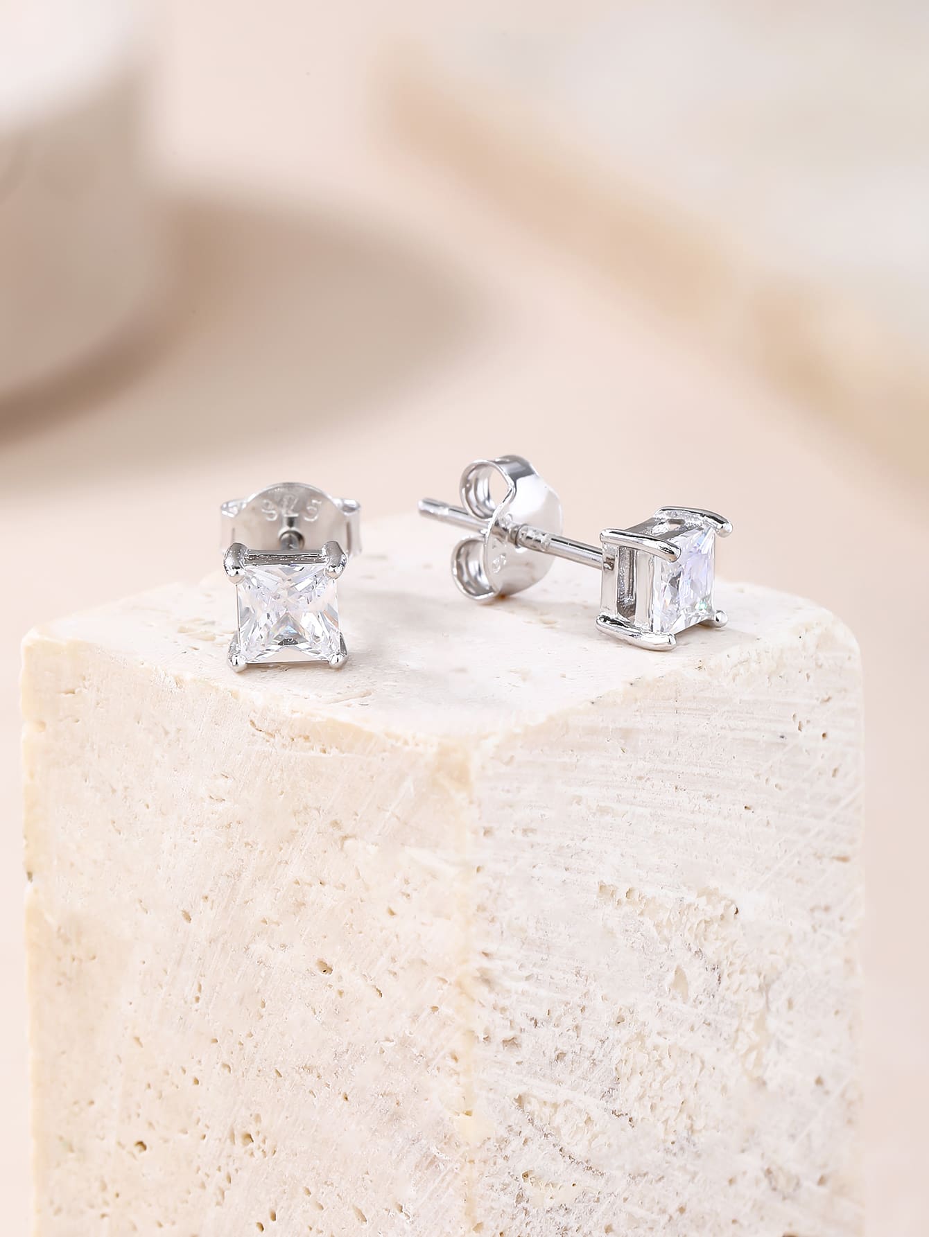 Square-cut white cubic zirconia four-prong stud earrings in hallmarked, rhodium-plated 925 sterling silver – display view – DRESCHER Jewellery®