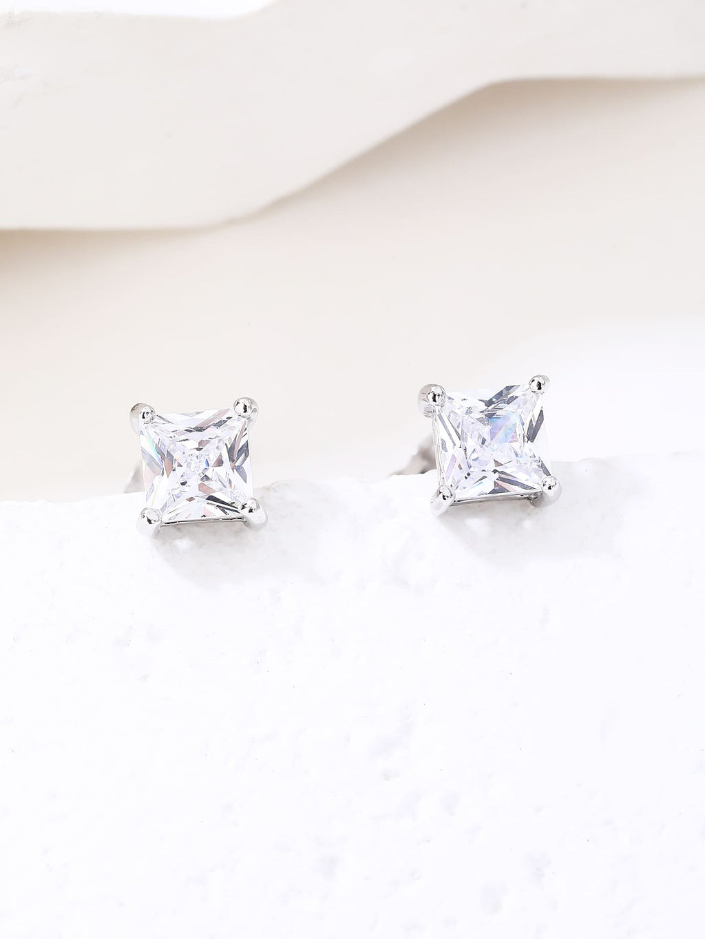 Square-cut white cubic zirconia four-prong stud earrings in hallmarked, rhodium-plated 925 sterling silver – display view – DRESCHER Jewellery®