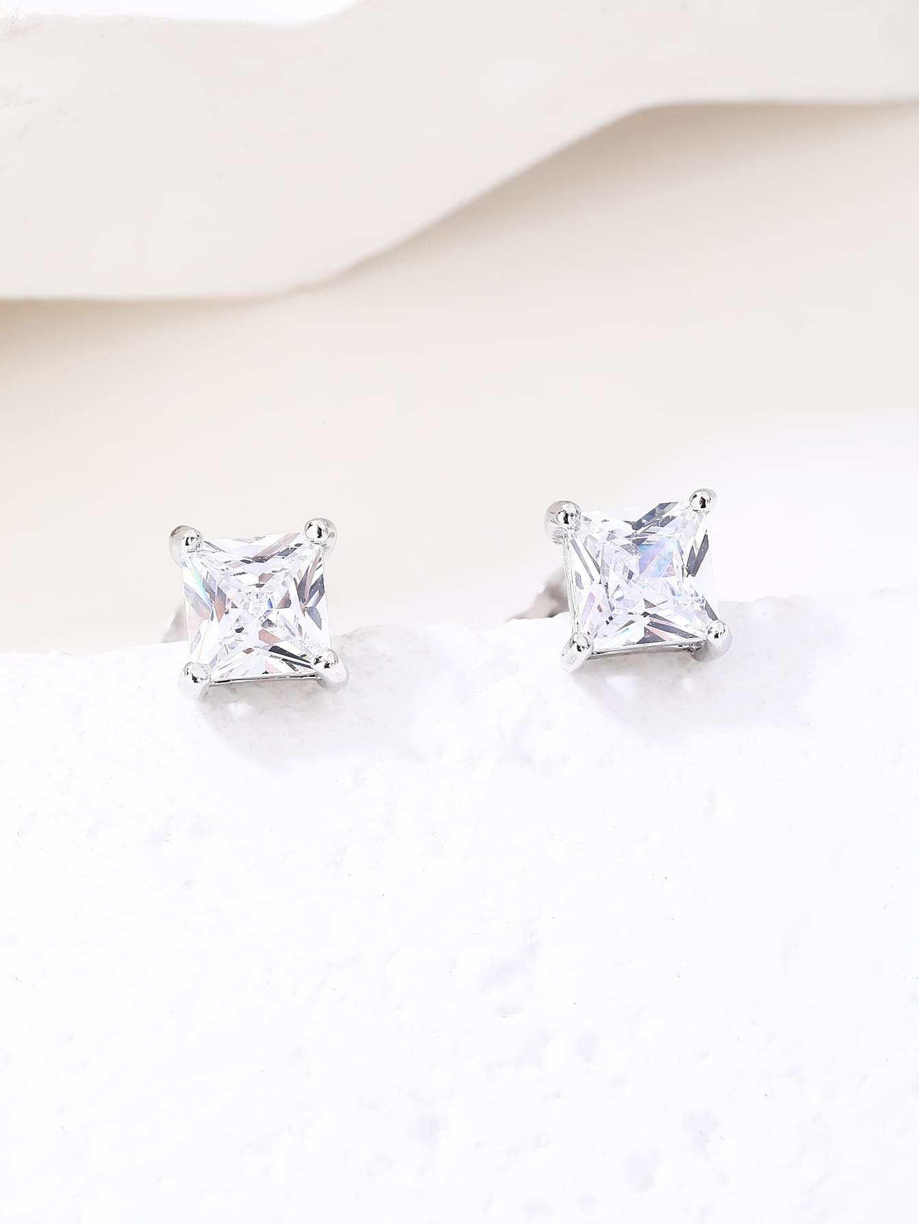 Square-cut white cubic zirconia four-prong stud earrings in hallmarked, rhodium-plated 925 sterling silver – display view – DRESCHER Jewellery®
