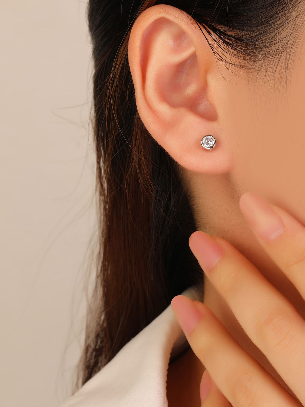 White cubic zirconia bezel-set stud earrings in hallmarked, rhodium-plated 925 sterling silver – worn view – DRESCHER Jewellery®