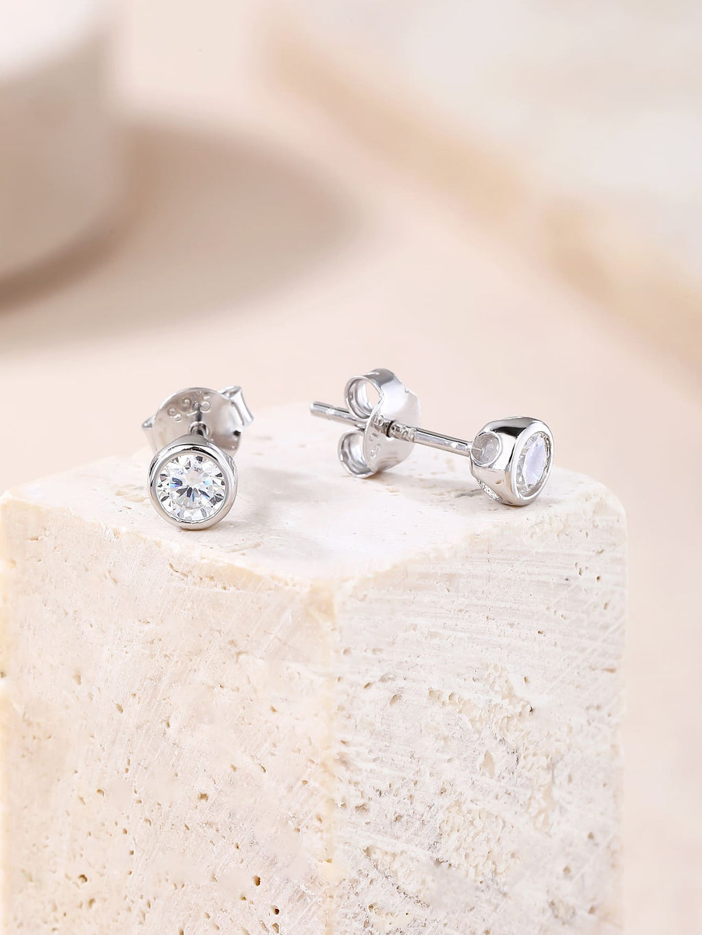 White cubic zirconia bezel-set stud earrings in hallmarked, rhodium-plated 925 sterling silver – display view – DRESCHER Jewellery®