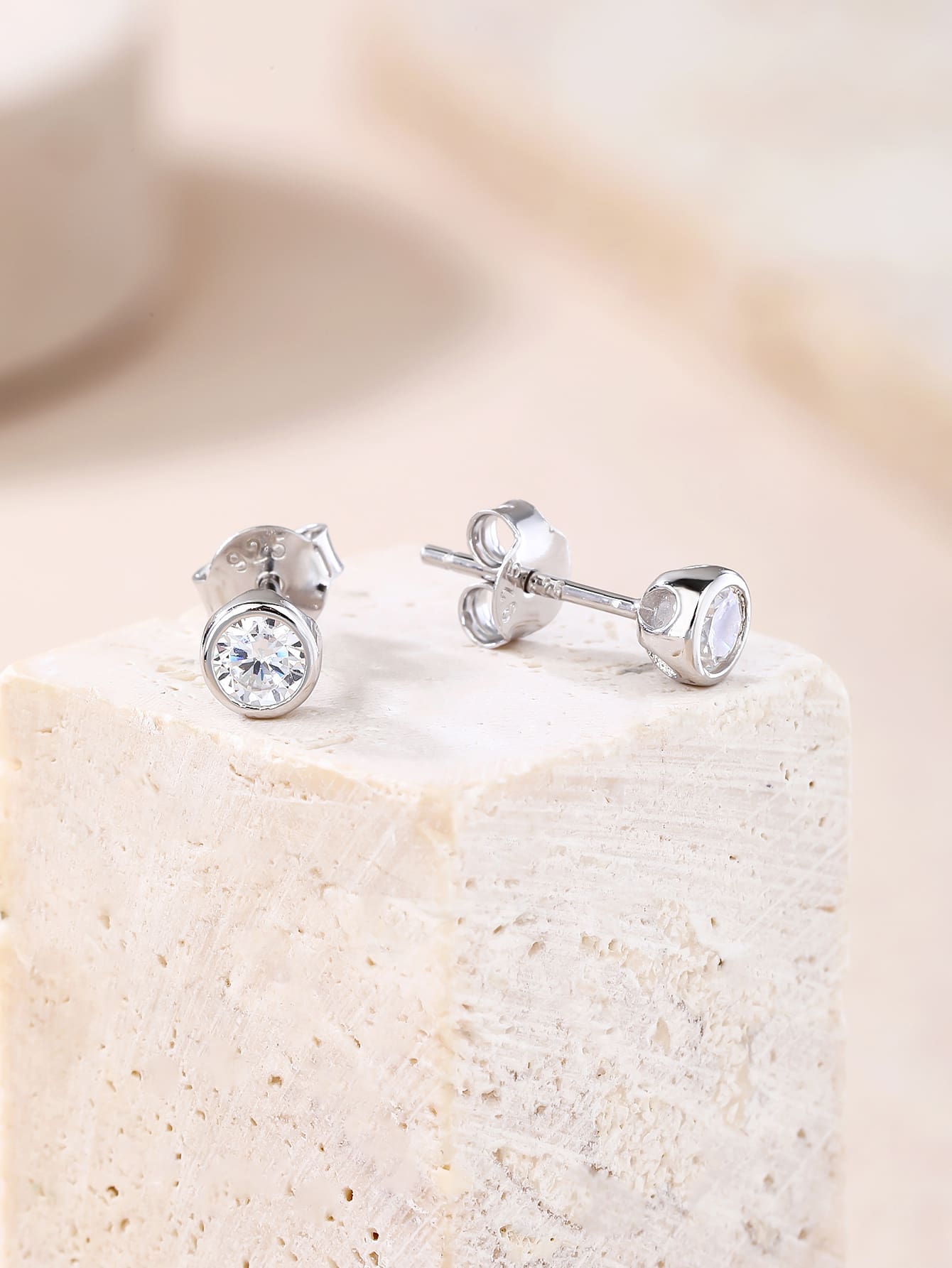 White cubic zirconia bezel-set stud earrings in hallmarked, rhodium-plated 925 sterling silver – display view – DRESCHER Jewellery®