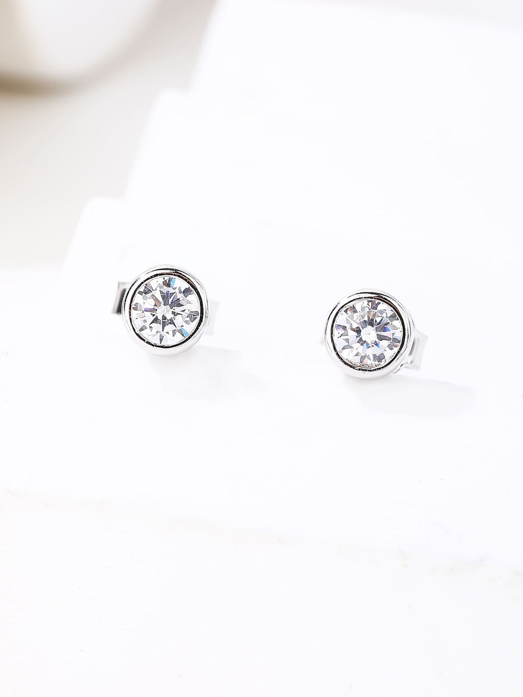 White cubic zirconia bezel-set stud earrings in hallmarked, rhodium-plated 925 sterling silver – display view – DRESCHER Jewellery®