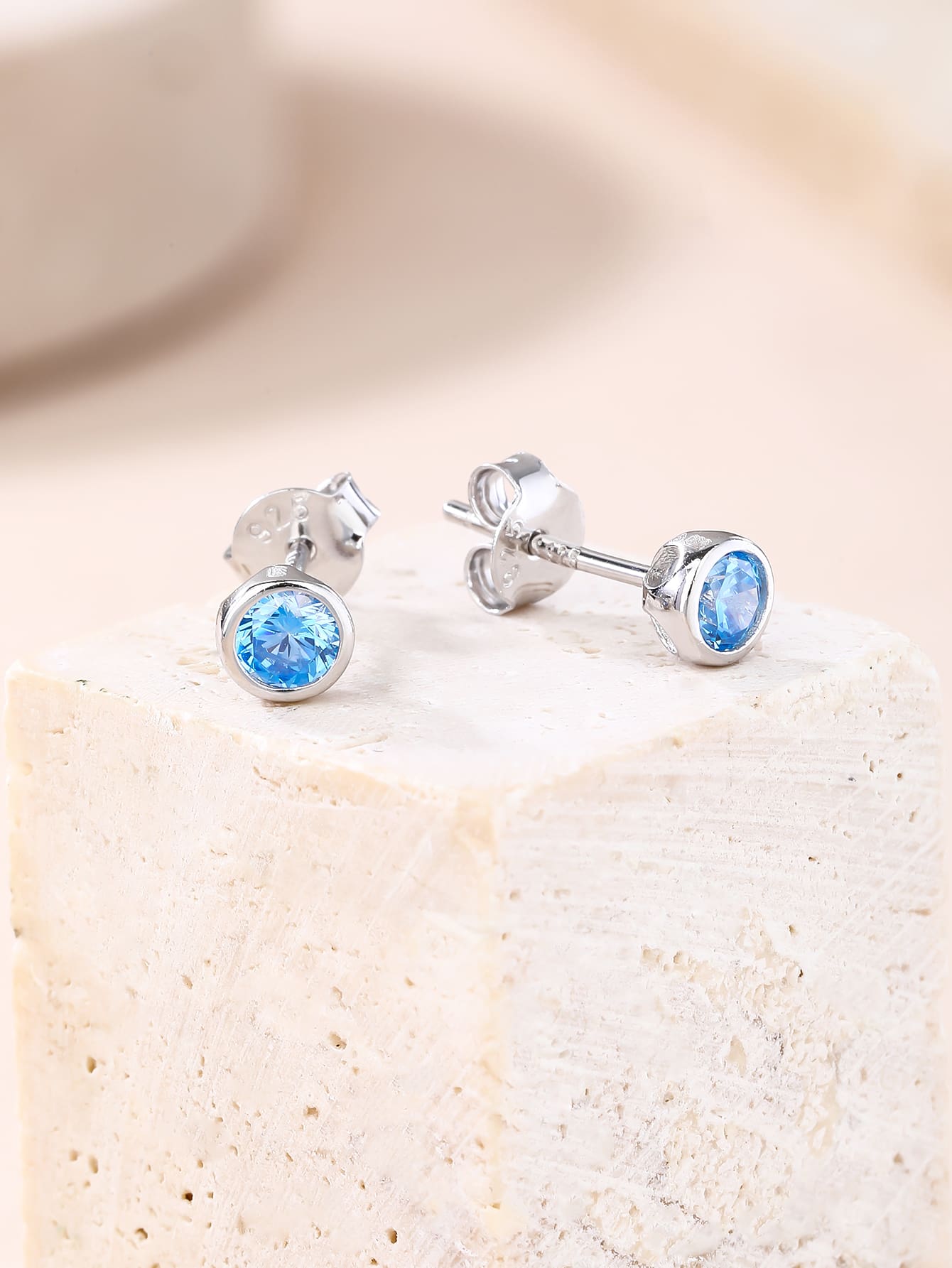 Blue cubic zirconia bezel-set stud earrings in hallmarked, rhodium-plated 925 sterling silver – display view – DRESCHER Jewellery®