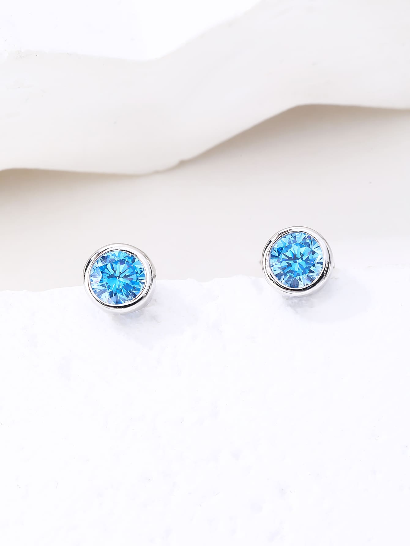 Blue cubic zirconia bezel-set stud earrings in hallmarked, rhodium-plated 925 sterling silver – display view – DRESCHER Jewellery®