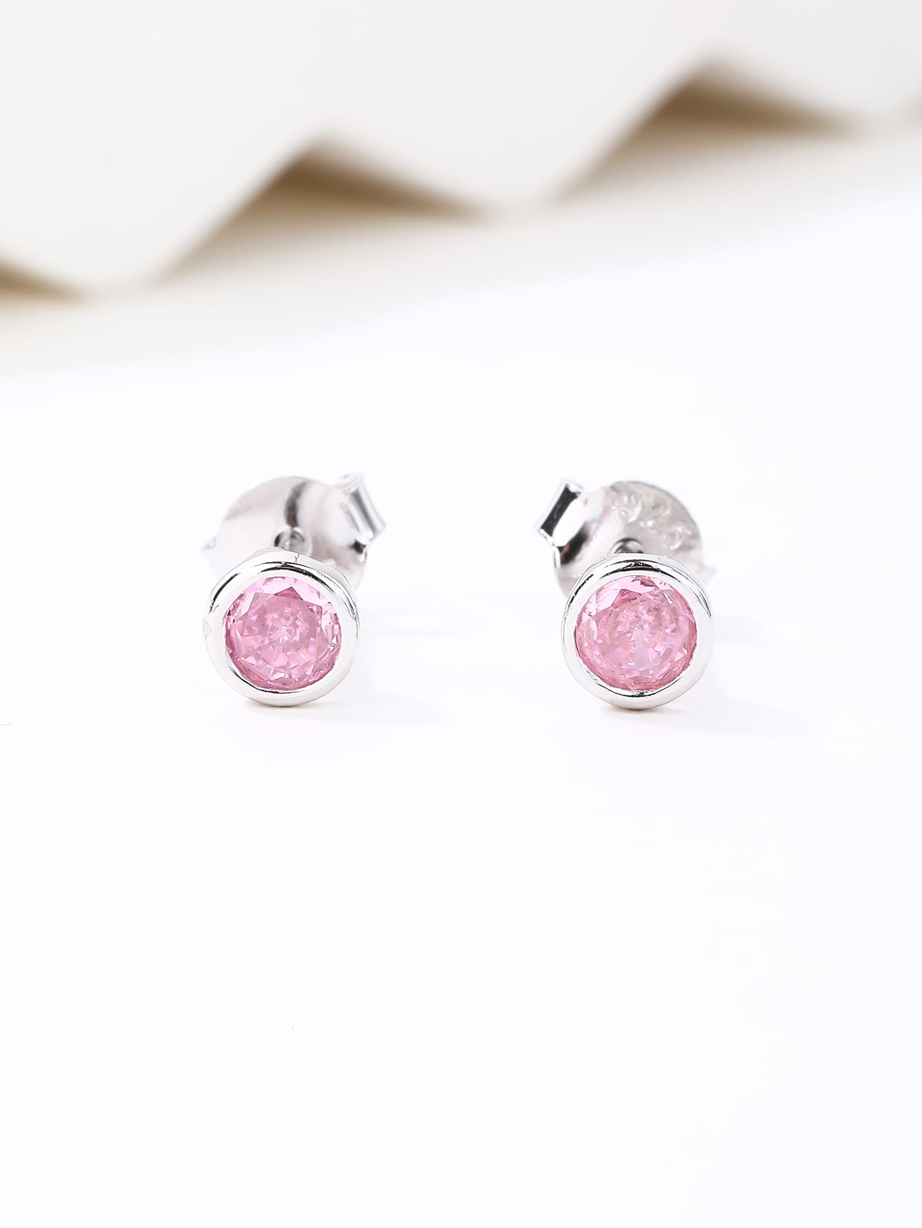 Pink cubic zirconia bezel-set stud earrings in hallmarked, rhodium-plated 925 sterling silver – display view – DRESCHER Jewellery®