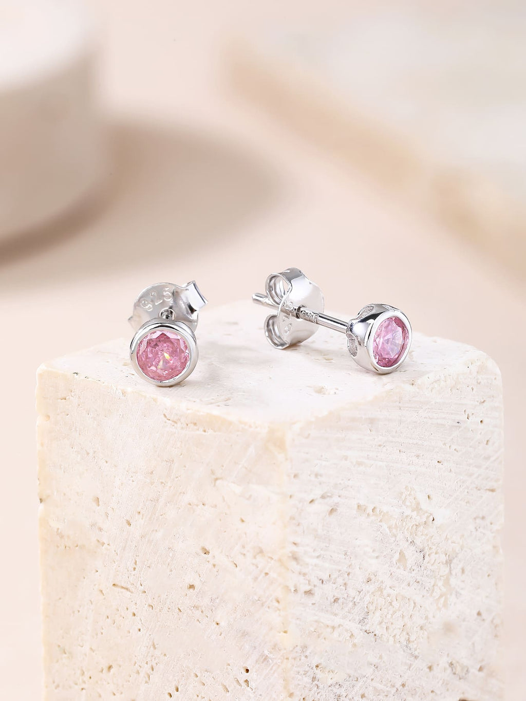 Pink cubic zirconia bezel-set stud earrings in hallmarked, rhodium-plated 925 sterling silver – display view – DRESCHER Jewellery®