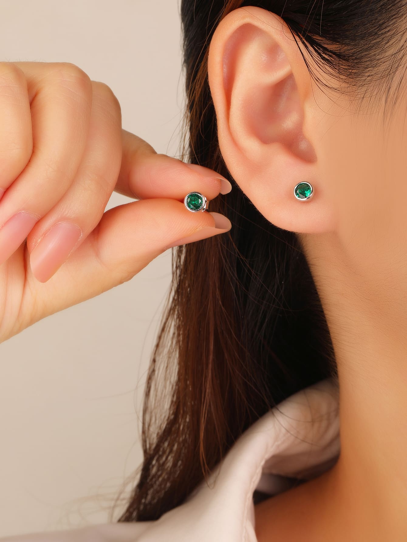 Green cubic zirconia button-set stud earrings in hallmarked, rhodium-plated 925 sterling silver – worn view – DRESCHER Jewellery®