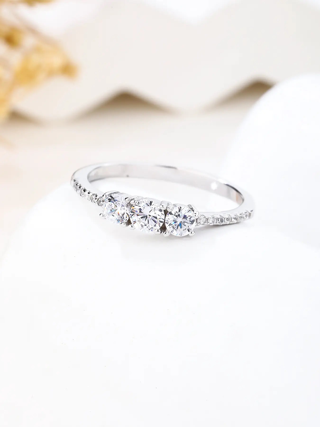 Silver engagement ring with three central and small cubic zirconia stones