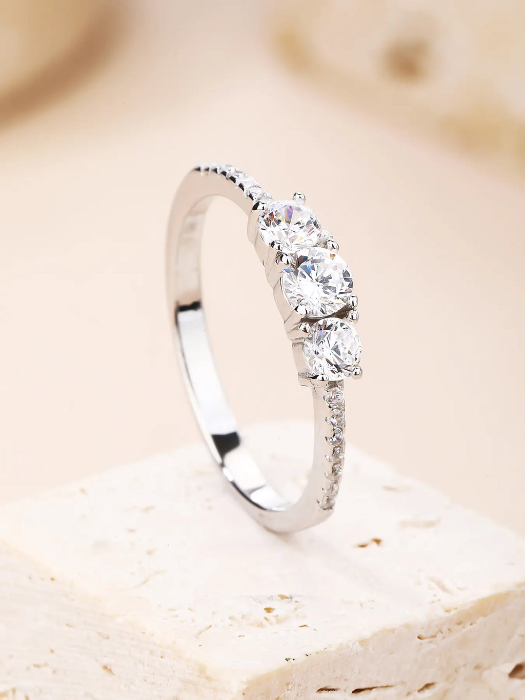 Silver engagement ring with three central and small cubic zirconia stones