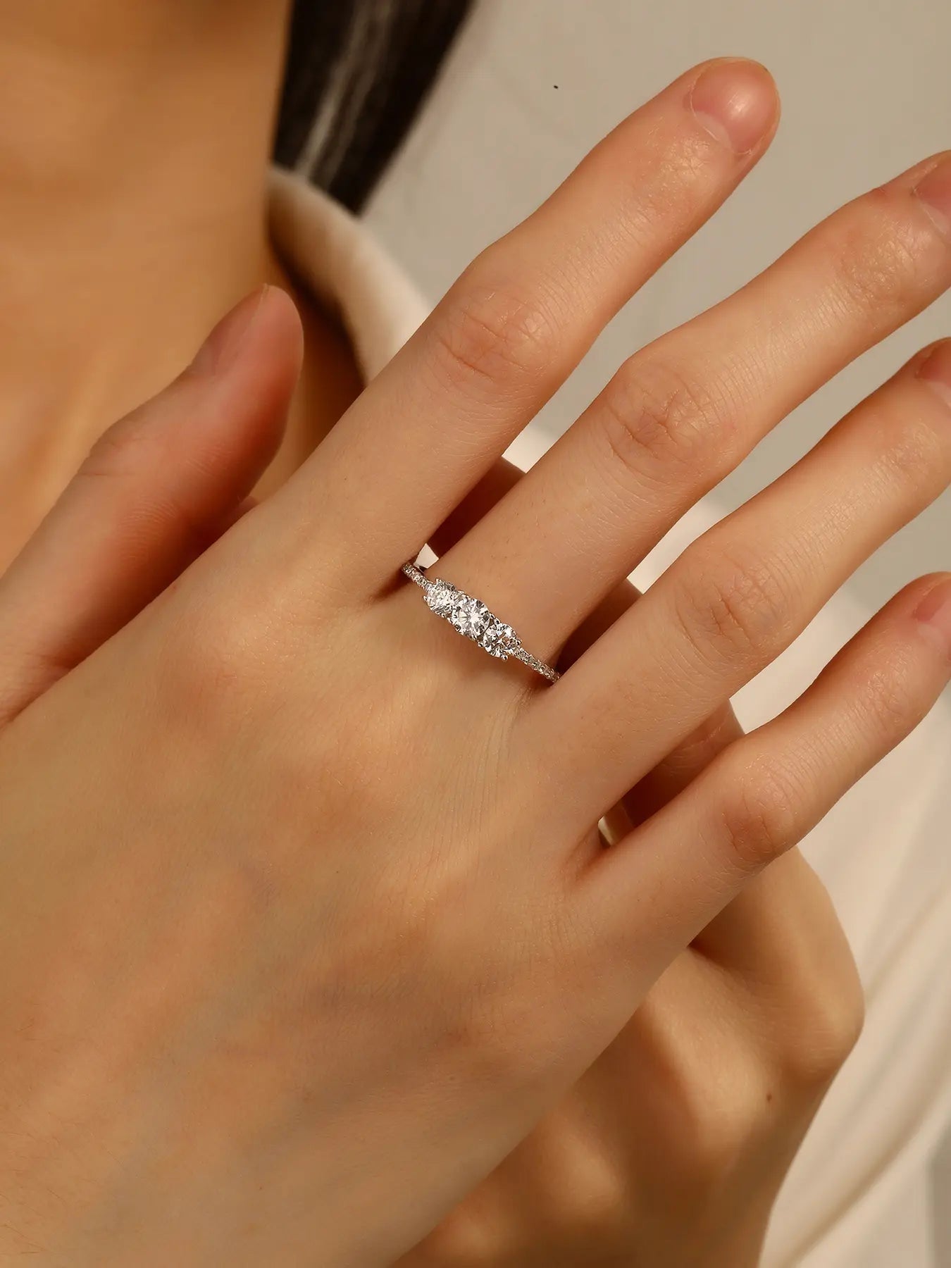 Silver engagement ring with three central and small cubic zirconia stones