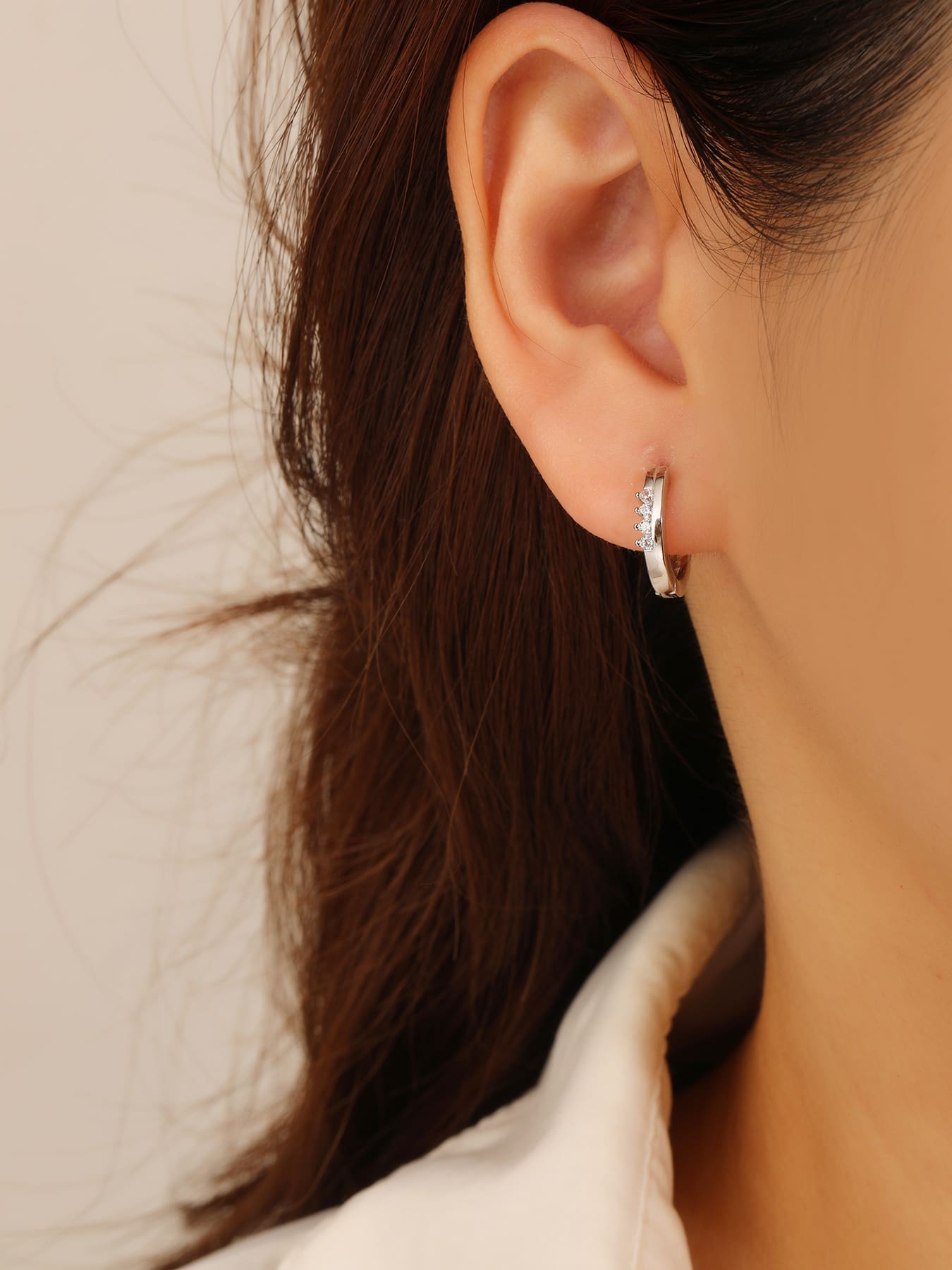 white cubic zirconia stone hoop earrings in hallmarked, rhodium-plated 925 sterling silver – worn view – DRESCHER Jewellery®