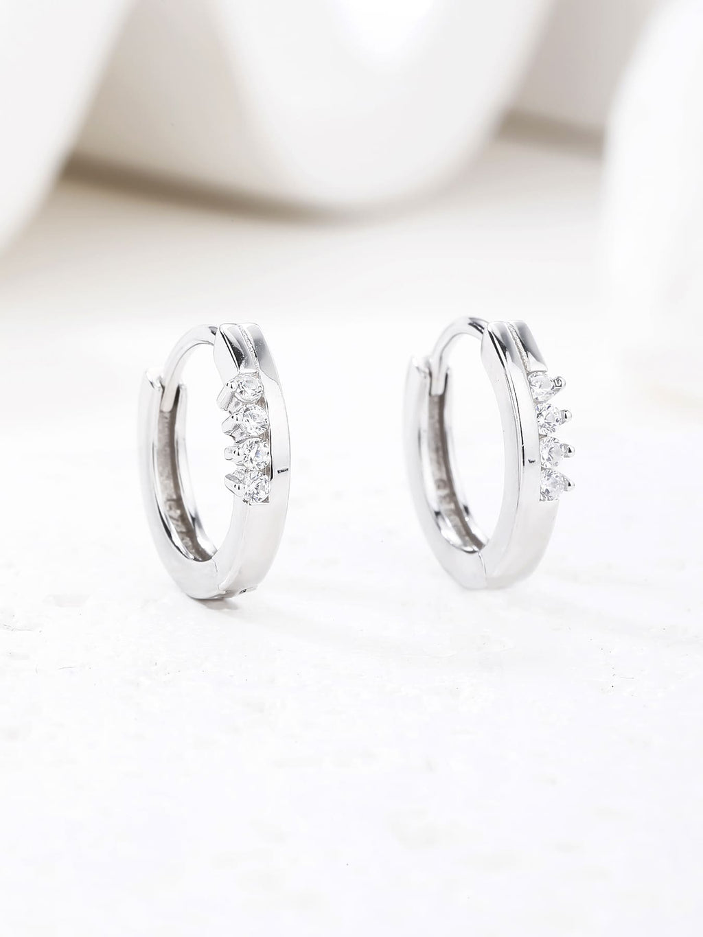 white cubic zirconia stone hoop earrings in hallmarked, rhodium-plated 925 sterling silver – lifestyle view – DRESCHER Jewellery®