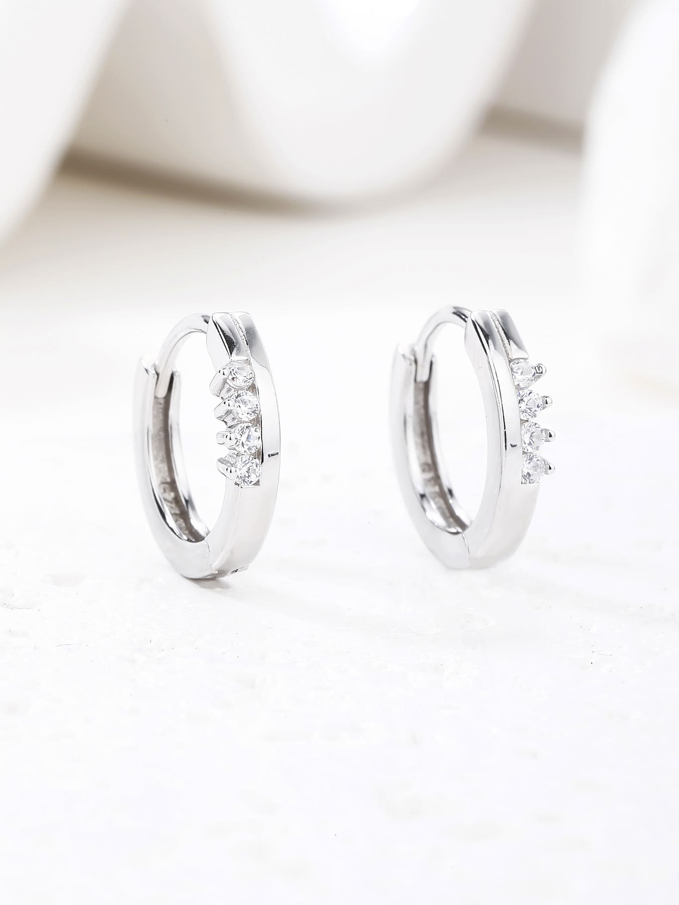 white cubic zirconia stone hoop earrings in hallmarked, rhodium-plated 925 sterling silver – lifestyle view – DRESCHER Jewellery®
