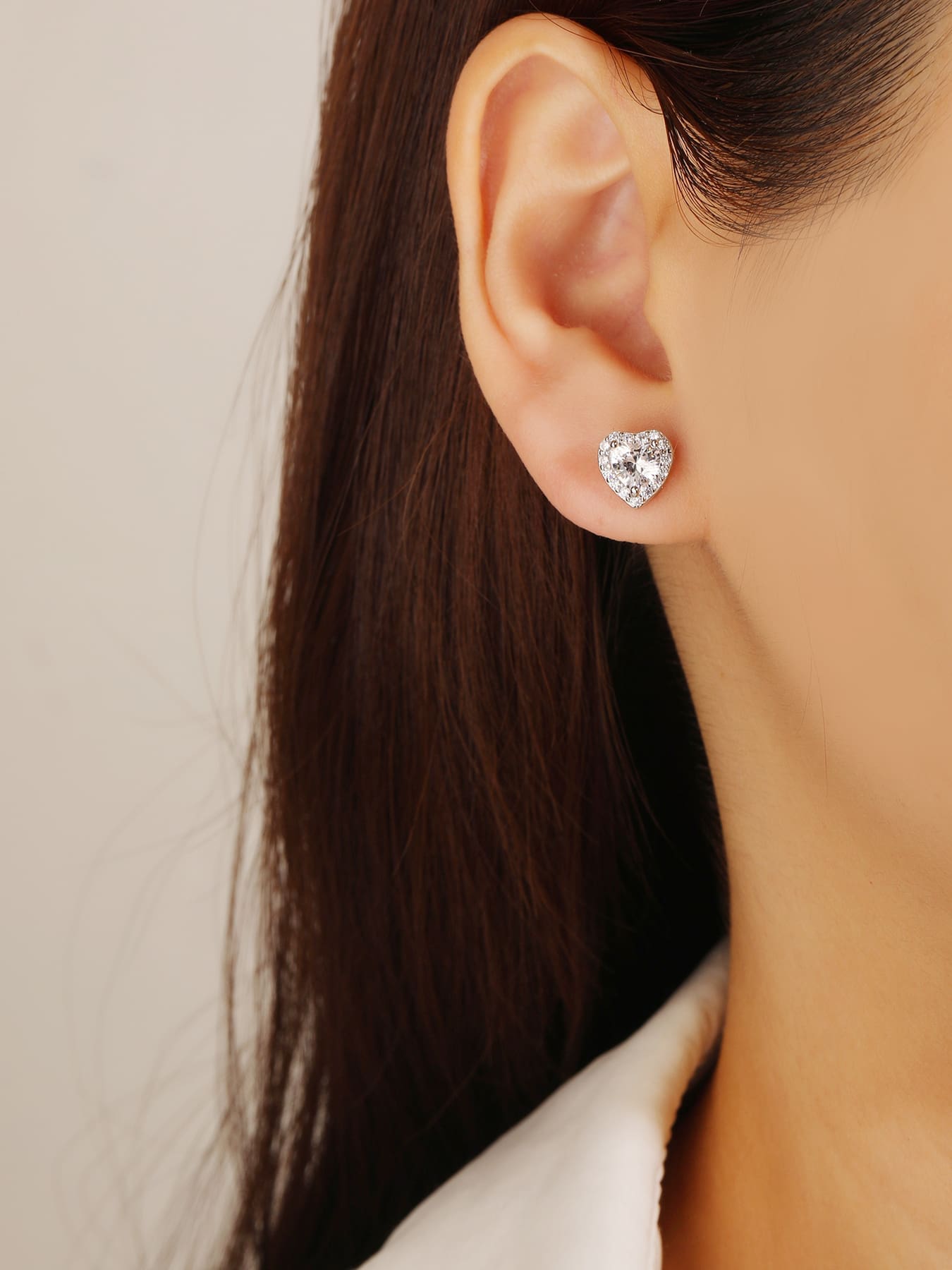 white heart shaped stone stud earrings with white cubic zirconia in hallmarked, rhodium-plated 925 sterling silver – worn view – DRESCHER Jewellery®
