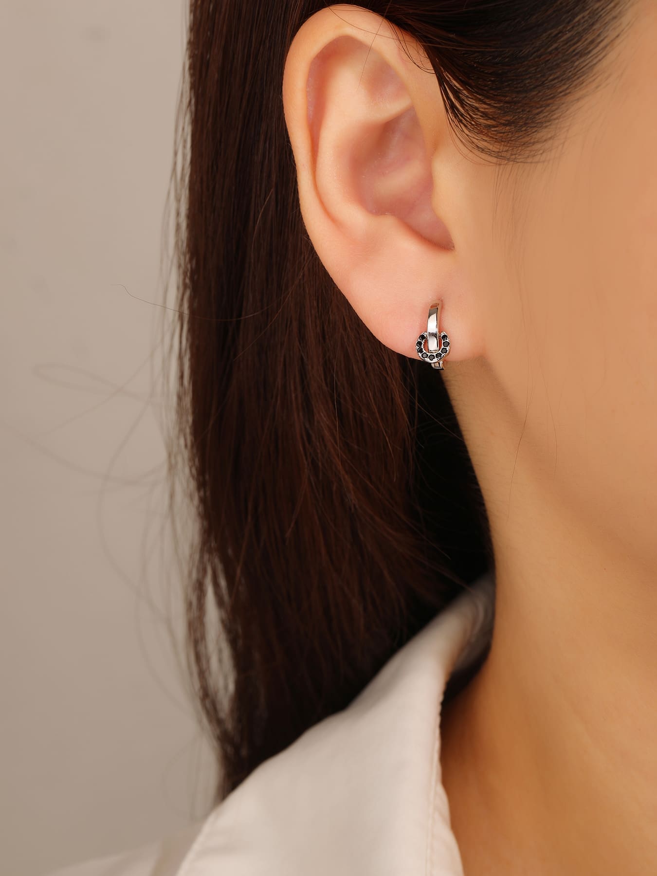 Black stone circle-detail hoop earrings in hallmarked, rhodium-plated 925 sterling silver – worn view – DRESCHER Jewellery®
