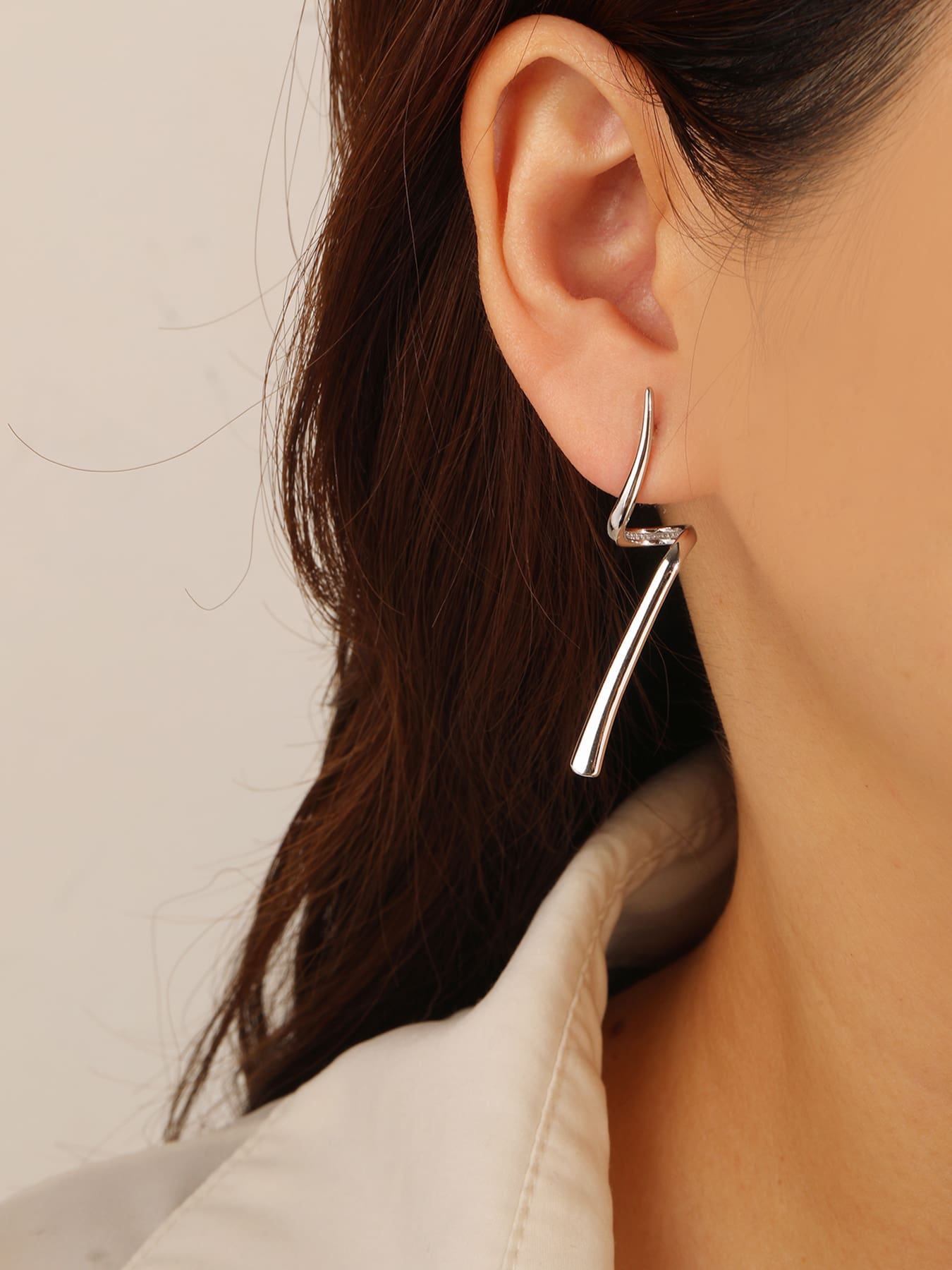 Abstract wave-form drop stud earrings in hallmarked, rhodium-plated 925 sterling silver – worn view – DRESCHER Jewellery®