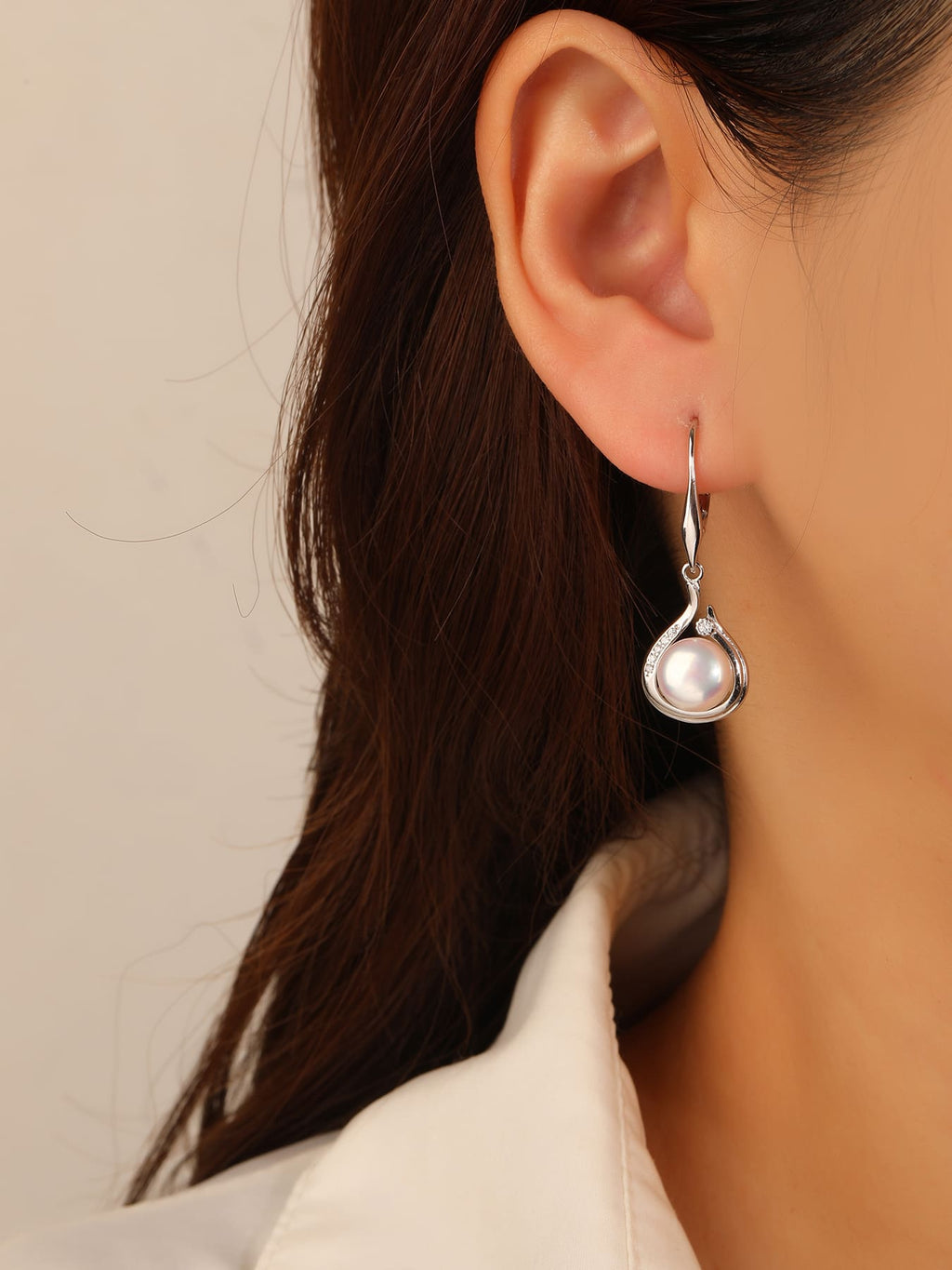 Pearl and white cubic zirconia teardrop leverback earrings, with silver components crafted from hallmarked, rhodium-plated 925 sterling silver – worn view – DRESCHER Jewellery®