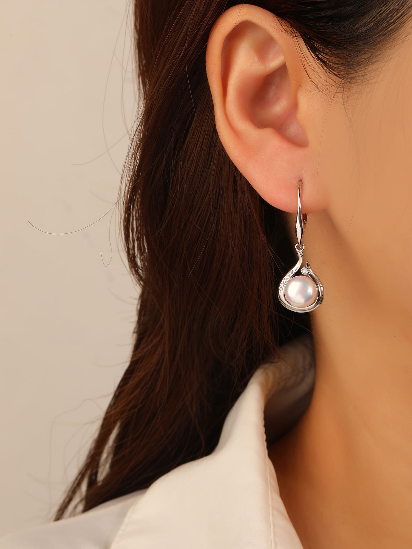 Pearl and white cubic zirconia teardrop leverback earrings, with silver components crafted from hallmarked, rhodium-plated 925 sterling silver – worn view – DRESCHER Jewellery®