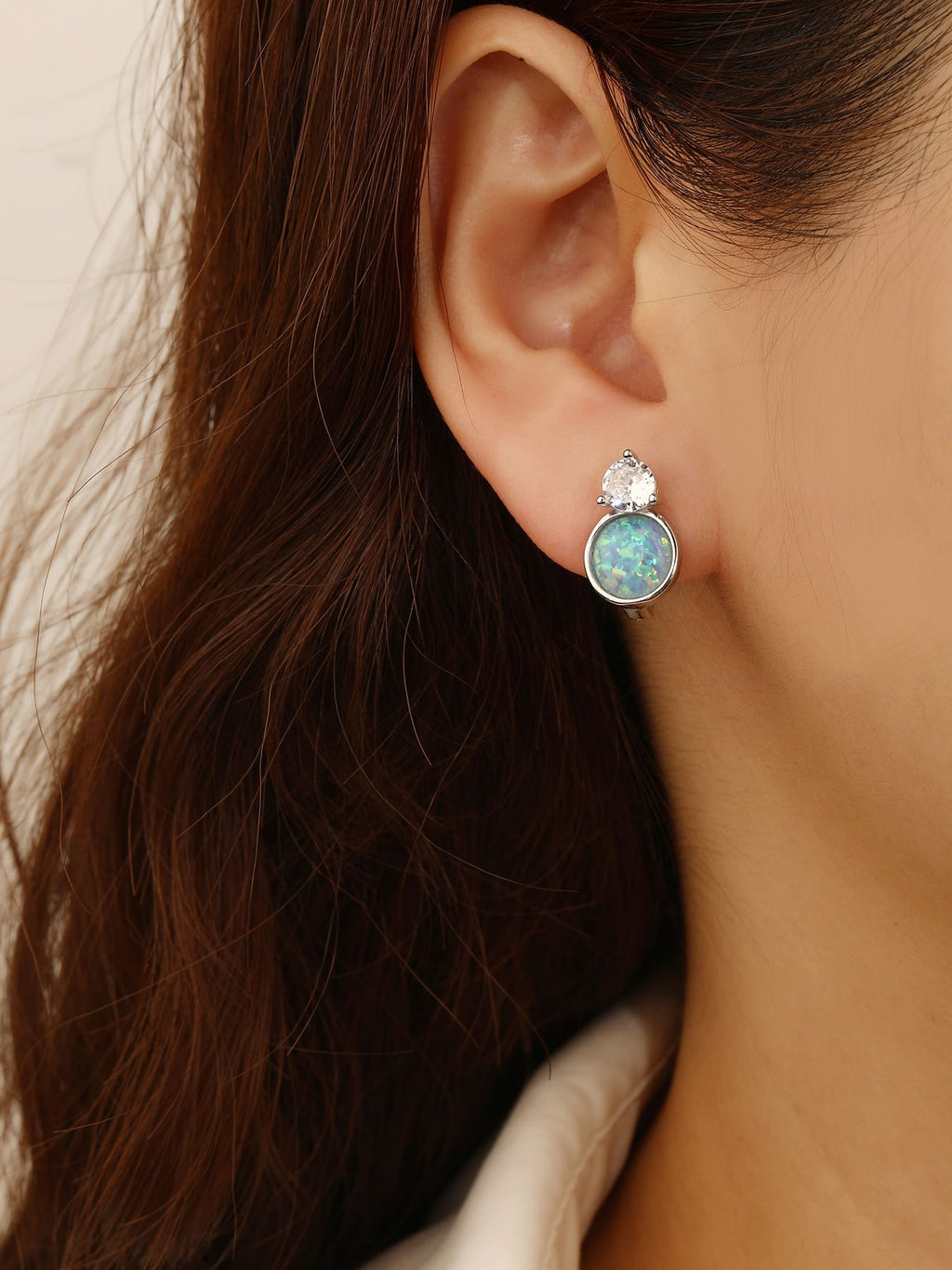 Light blue opal and white cubic zirconia huggie earrings in hallmarked, rhodium-plated 925 sterling silver – worn view – DRESCHER Jewellery®