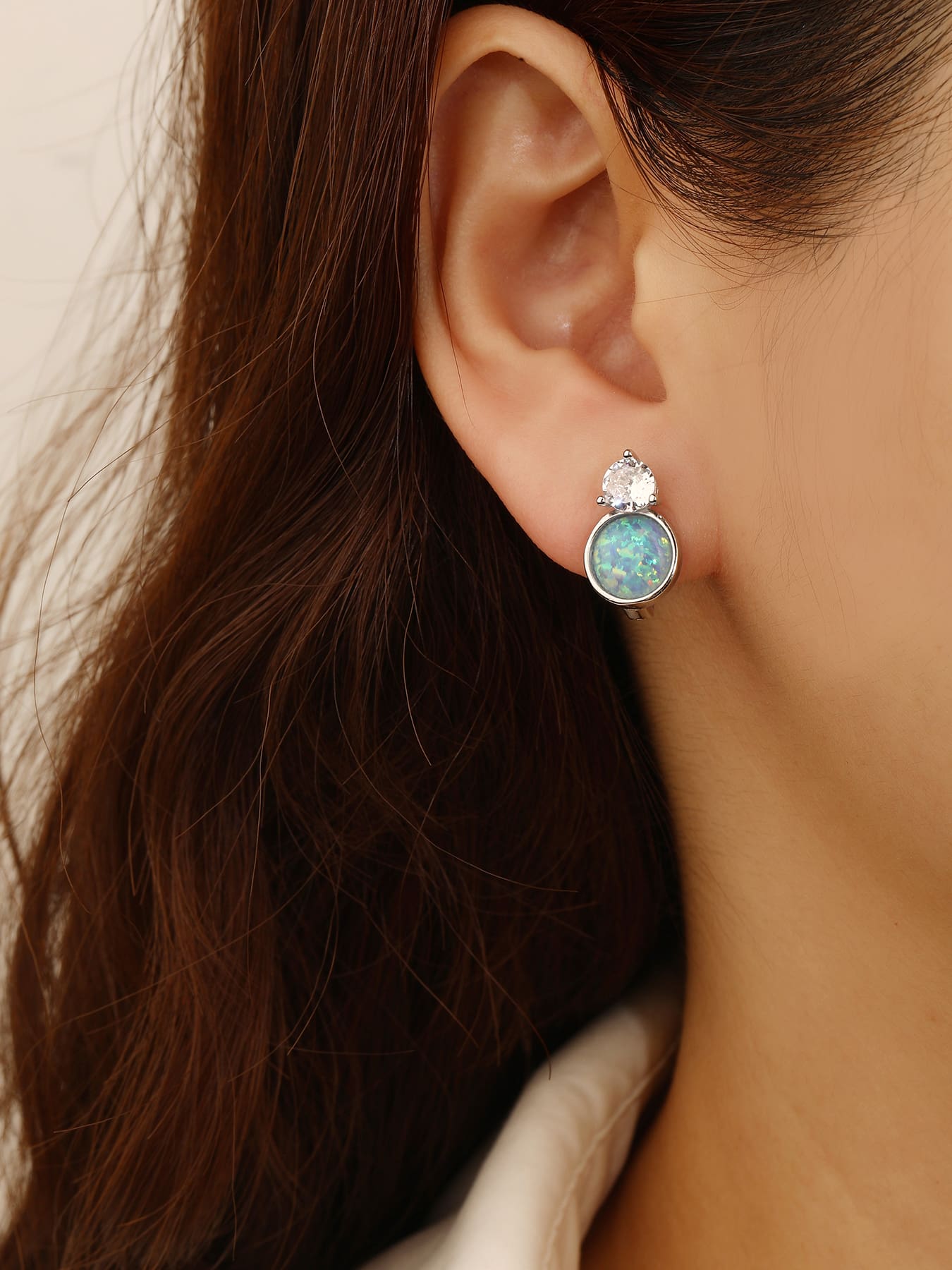 Light blue opal and white cubic zirconia huggie earrings in hallmarked, rhodium-plated 925 sterling silver – worn view – DRESCHER Jewellery®