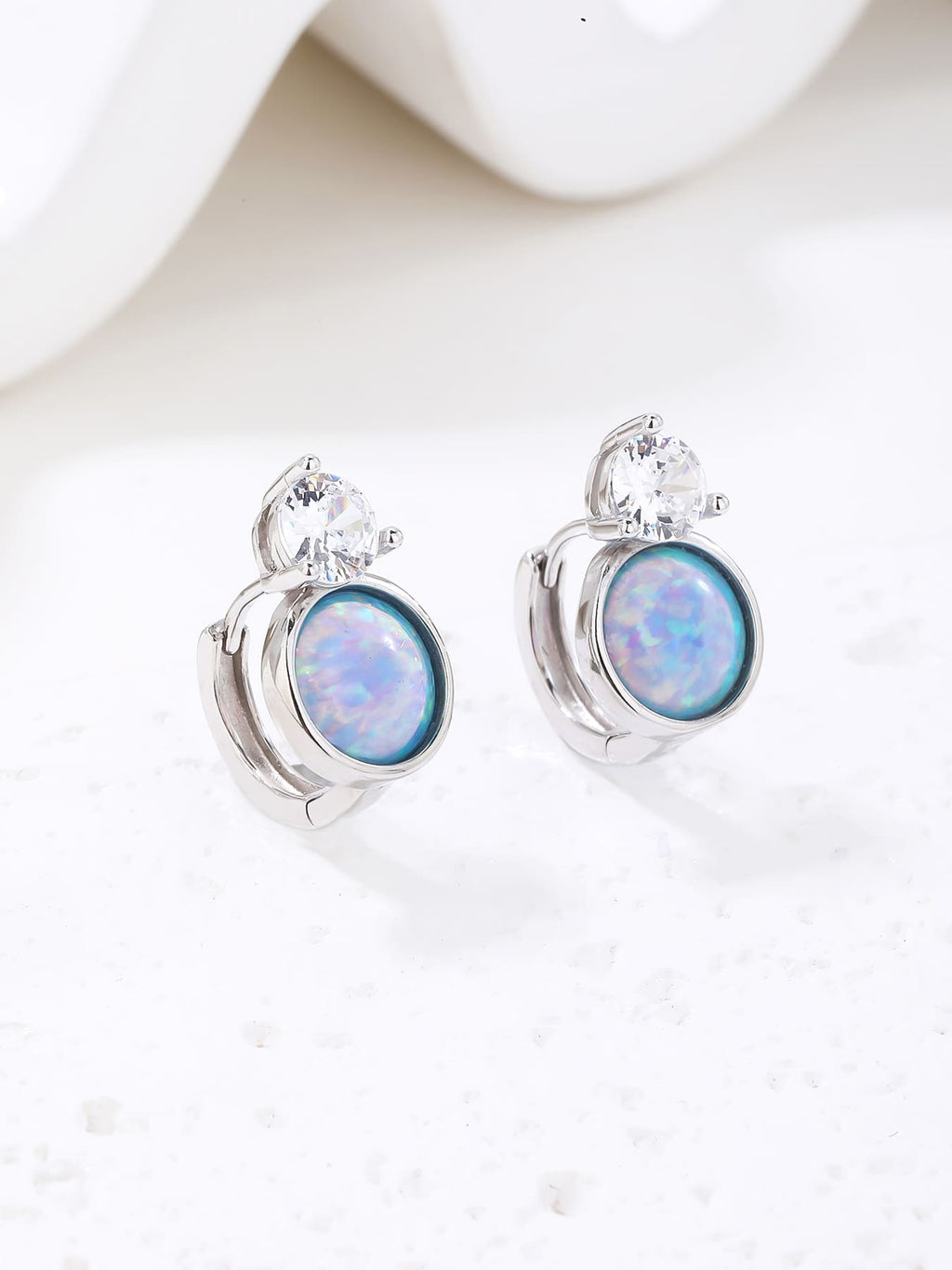 Light blue opal and white cubic zirconia huggie earrings in hallmarked, rhodium-plated 925 sterling silver – display view – DRESCHER Jewellery®