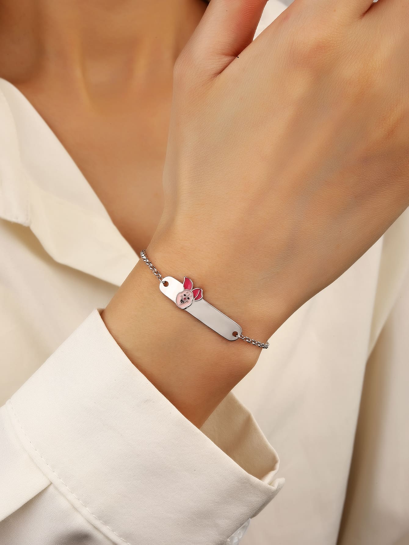 Pink enamel pig hallmarked, rhodium-plated 925 sterling silver children’s ID bracelet – worn view – DRESCHER Jewellery®