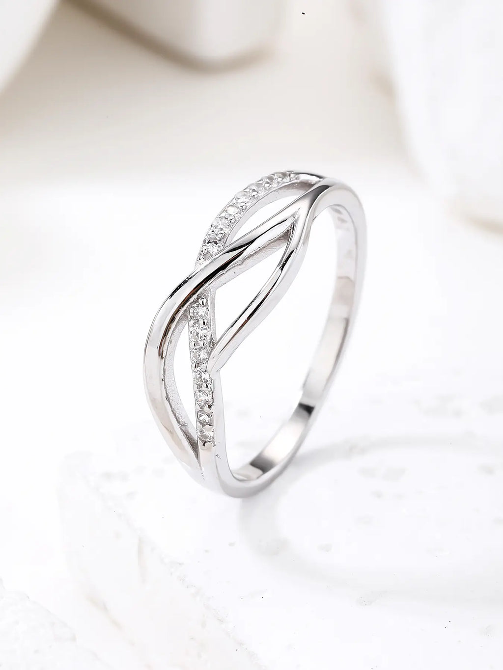 Silver ring with curved motif and white stones