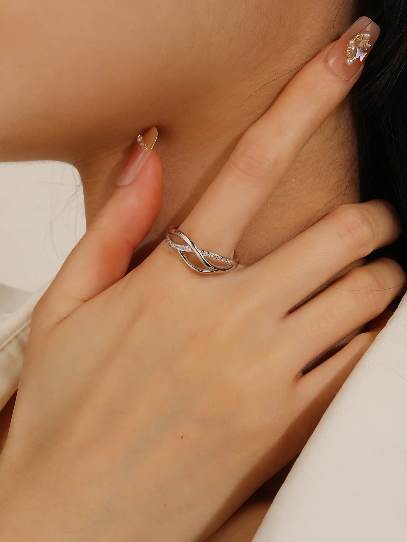 Silver ring with curved motif and white stones