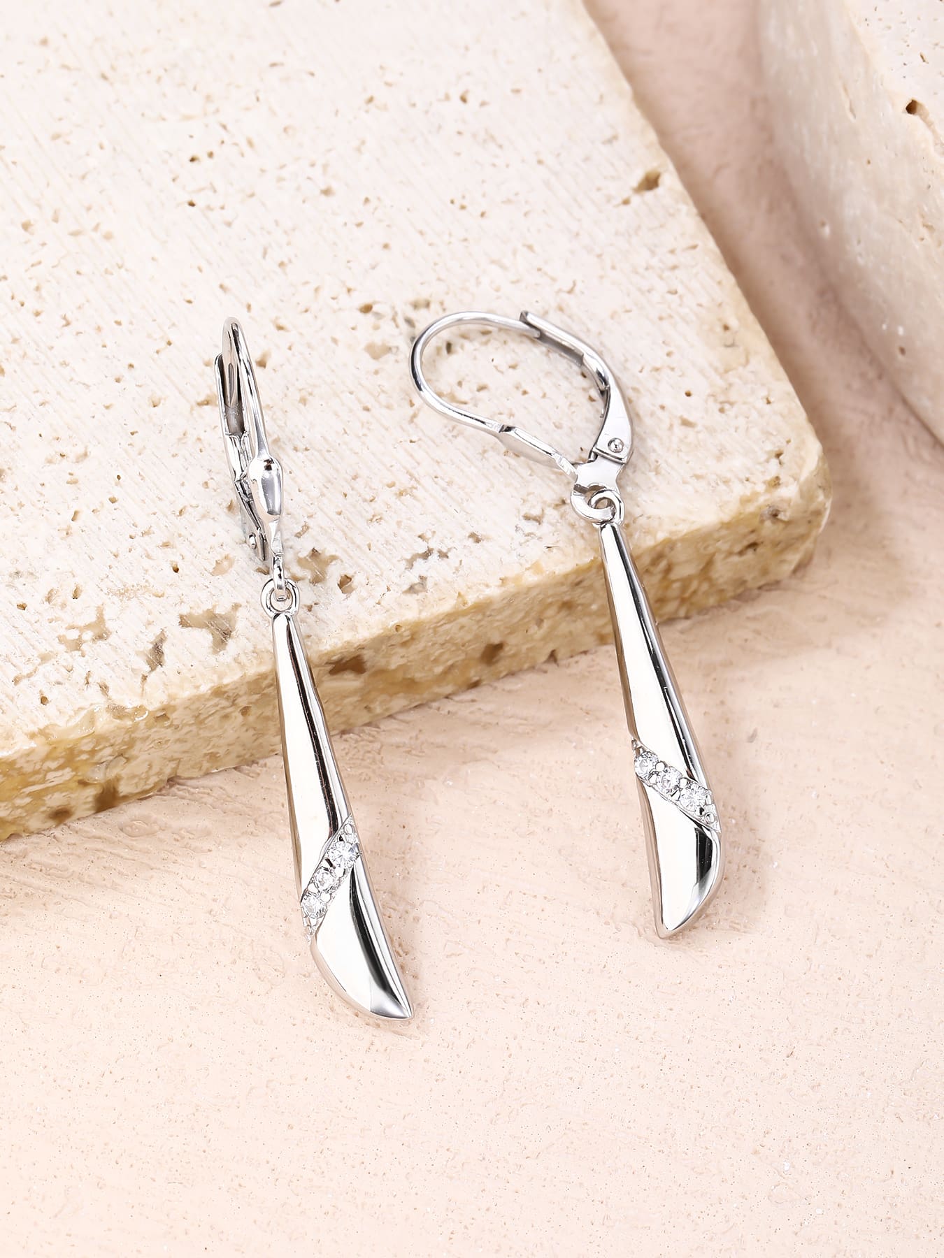 Elongated curved white cubic zirconia leverback earrings in hallmarked, rhodium-plated 925 sterling silver – lifestyle view – DRESCHER Jewellery®