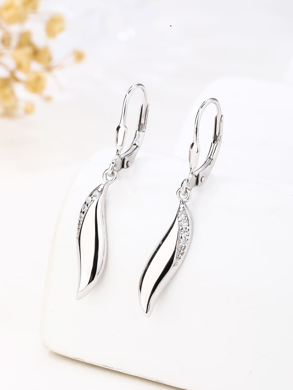 wave shaped cubic zirconia stone earrings with patent closure in hallmarked, rhodium-plated 925 sterling silver – lifestyle view – DRESCHER Jewellery®