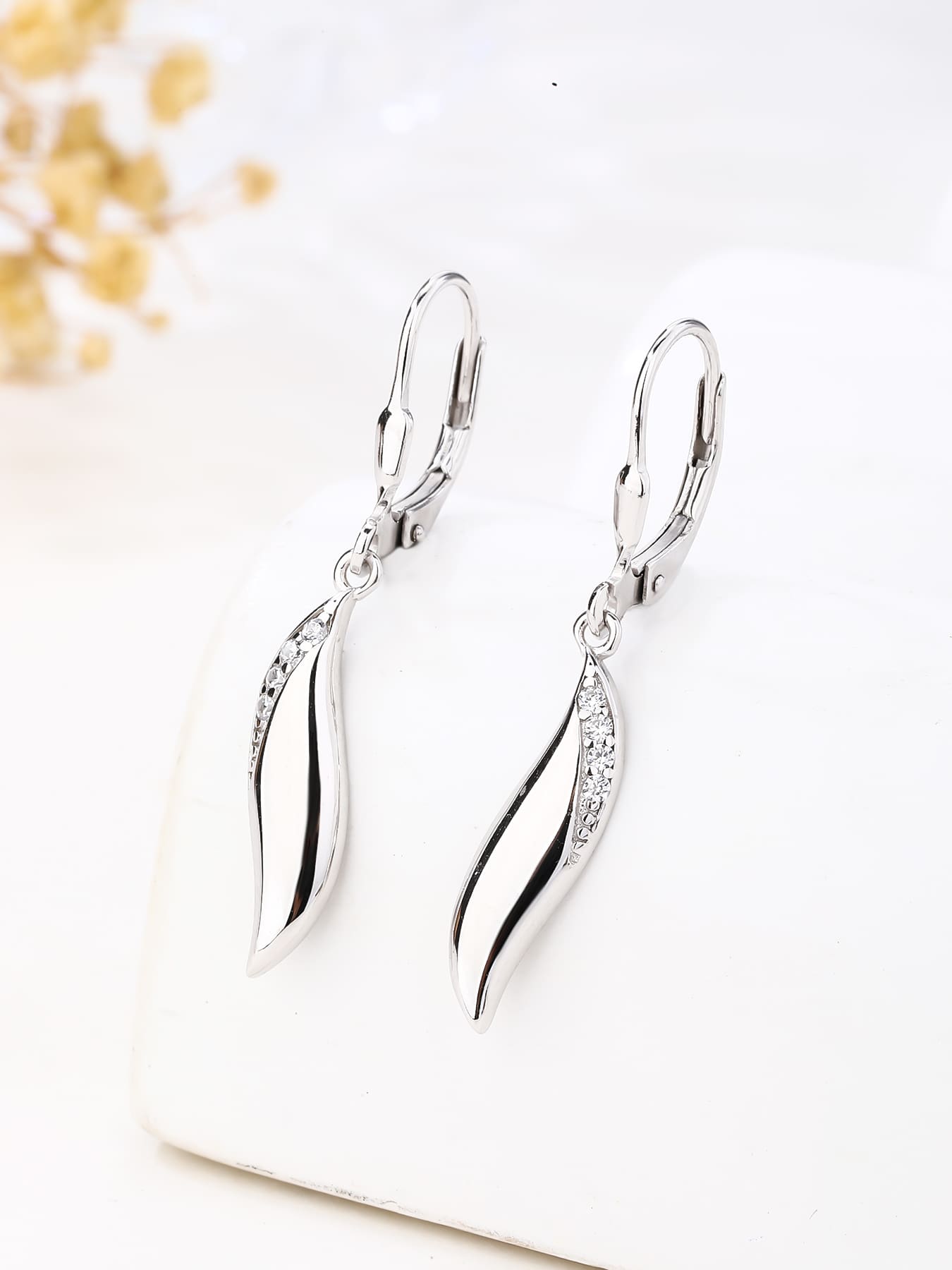 wave shaped cubic zirconia stone earrings with patent closure in hallmarked, rhodium-plated 925 sterling silver – lifestyle view – DRESCHER Jewellery®