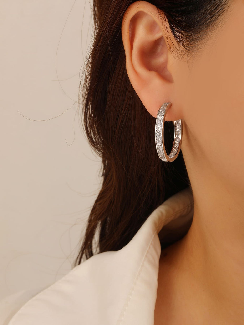 Double-row white cubic zirconia hoop earrings in hallmarked, rhodium-plated 925 sterling silver – worn view – DRESCHER Jewellery®