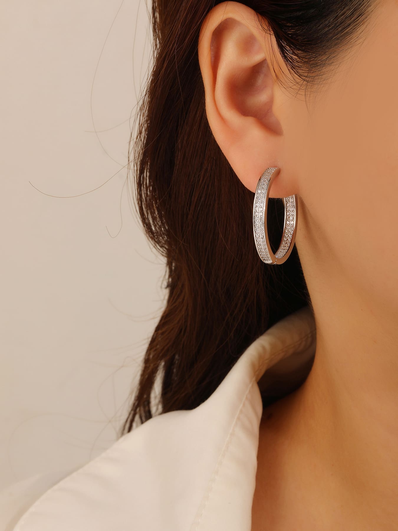 Double-row white cubic zirconia hoop earrings in hallmarked, rhodium-plated 925 sterling silver – worn view – DRESCHER Jewellery®