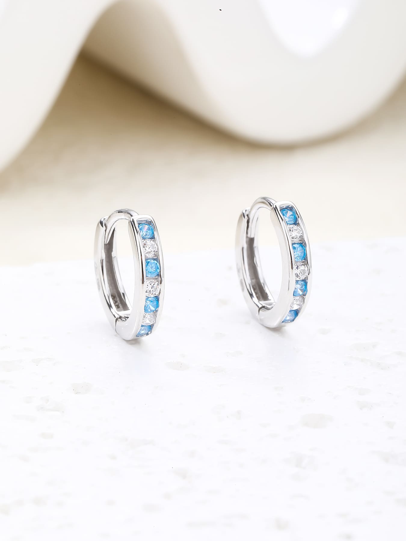 Blue and white cubic zirconia hoop earrings in hallmarked, rhodium-plated 925 sterling silver – display view – DRESCHER Jewellery®