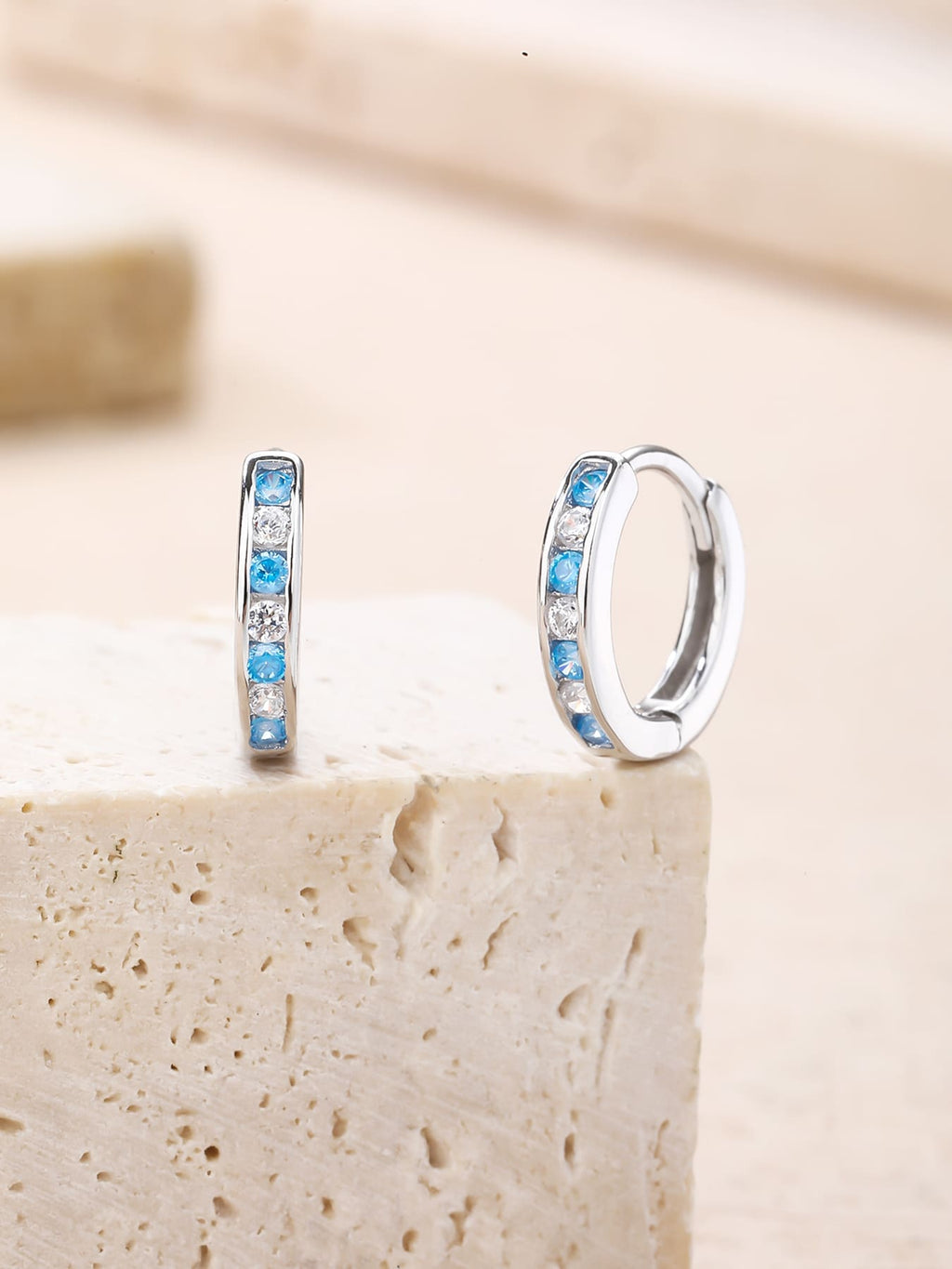 Blue and white cubic zirconia hoop earrings in hallmarked, rhodium-plated 925 sterling silver – lifestyle view – DRESCHER Jewellery®