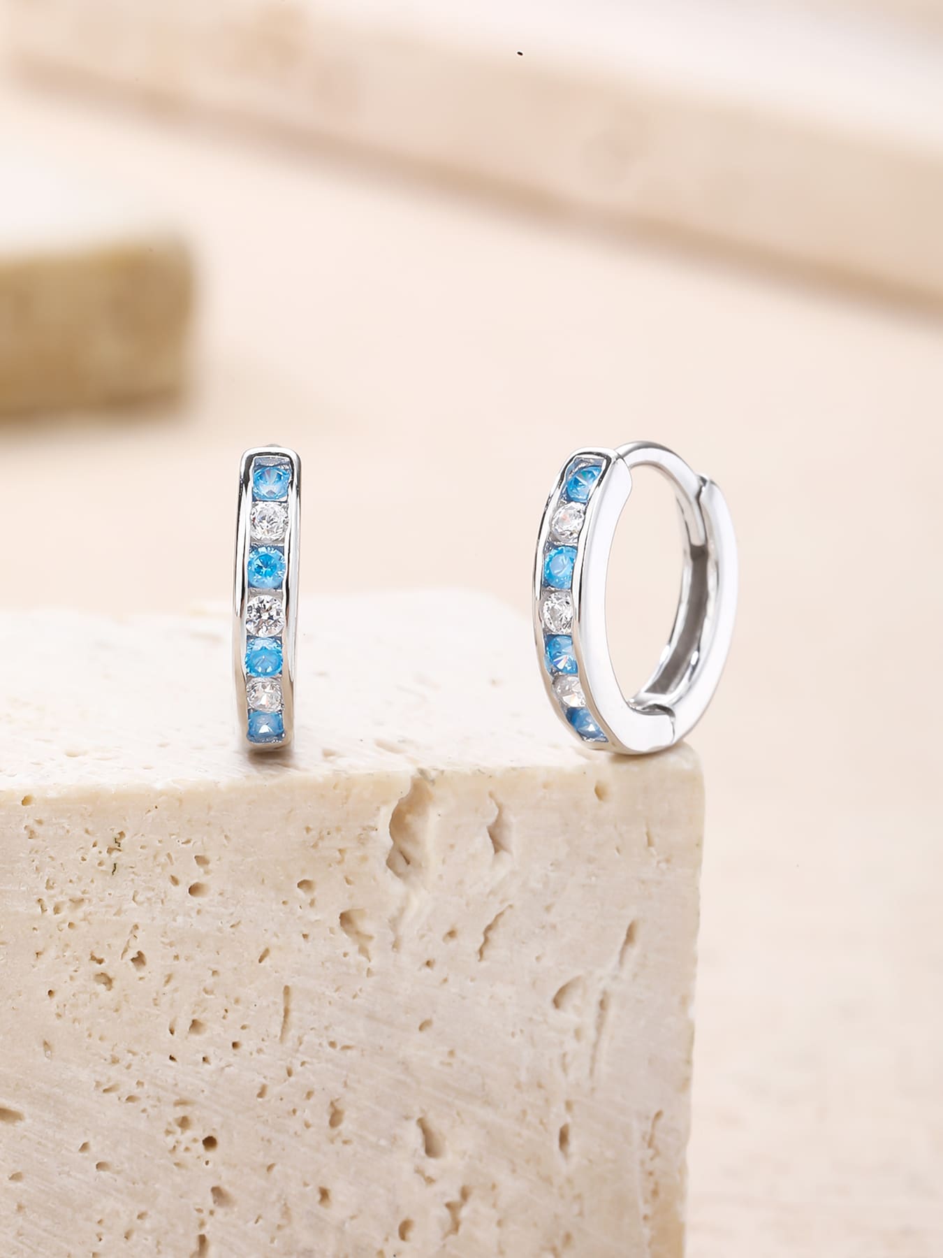 Blue and white cubic zirconia hoop earrings in hallmarked, rhodium-plated 925 sterling silver – lifestyle view – DRESCHER Jewellery®