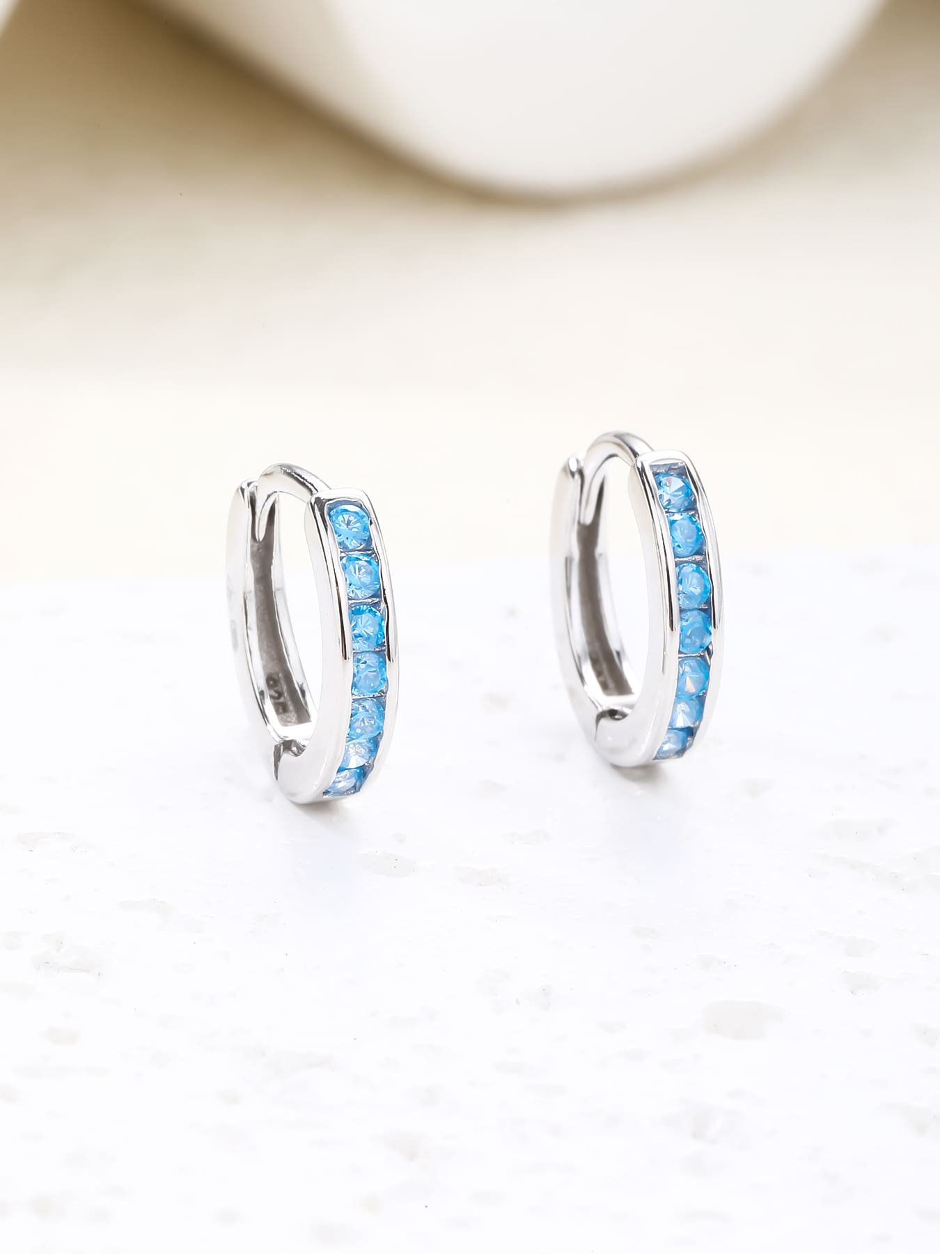Light blue cubic zirconia hoop earrings in hallmarked, rhodium-plated 925 sterling silver – display view – DRESCHER Jewellery®