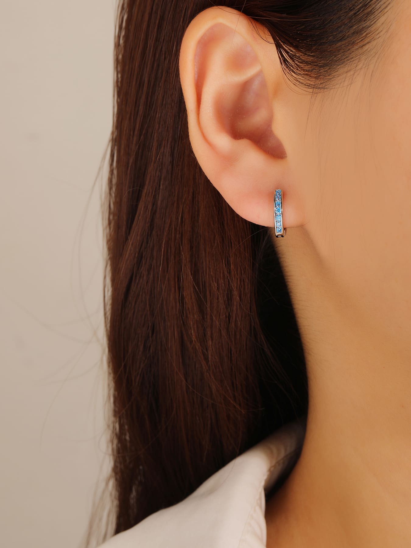 Light blue cubic zirconia hoop earrings in hallmarked, rhodium-plated 925 sterling silver – worn view – DRESCHER Jewellery®