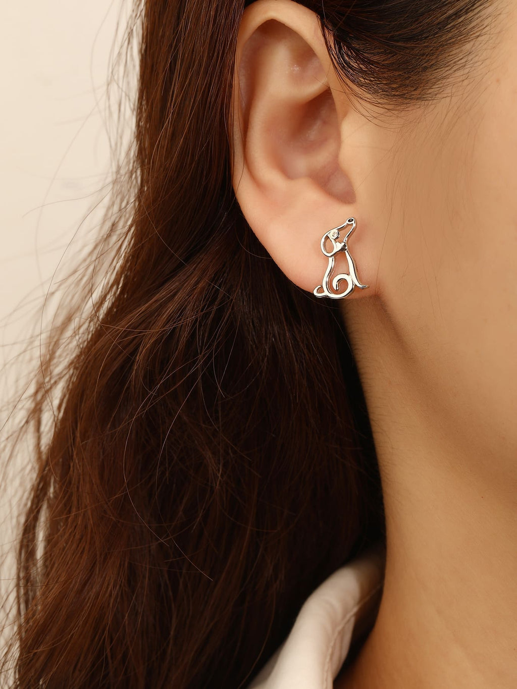 Dog-shaped stud earrings with cubic zirconia eyes in hallmarked, rhodium-plated 925 sterling silver – worn view – DRESCHER Jewellery®