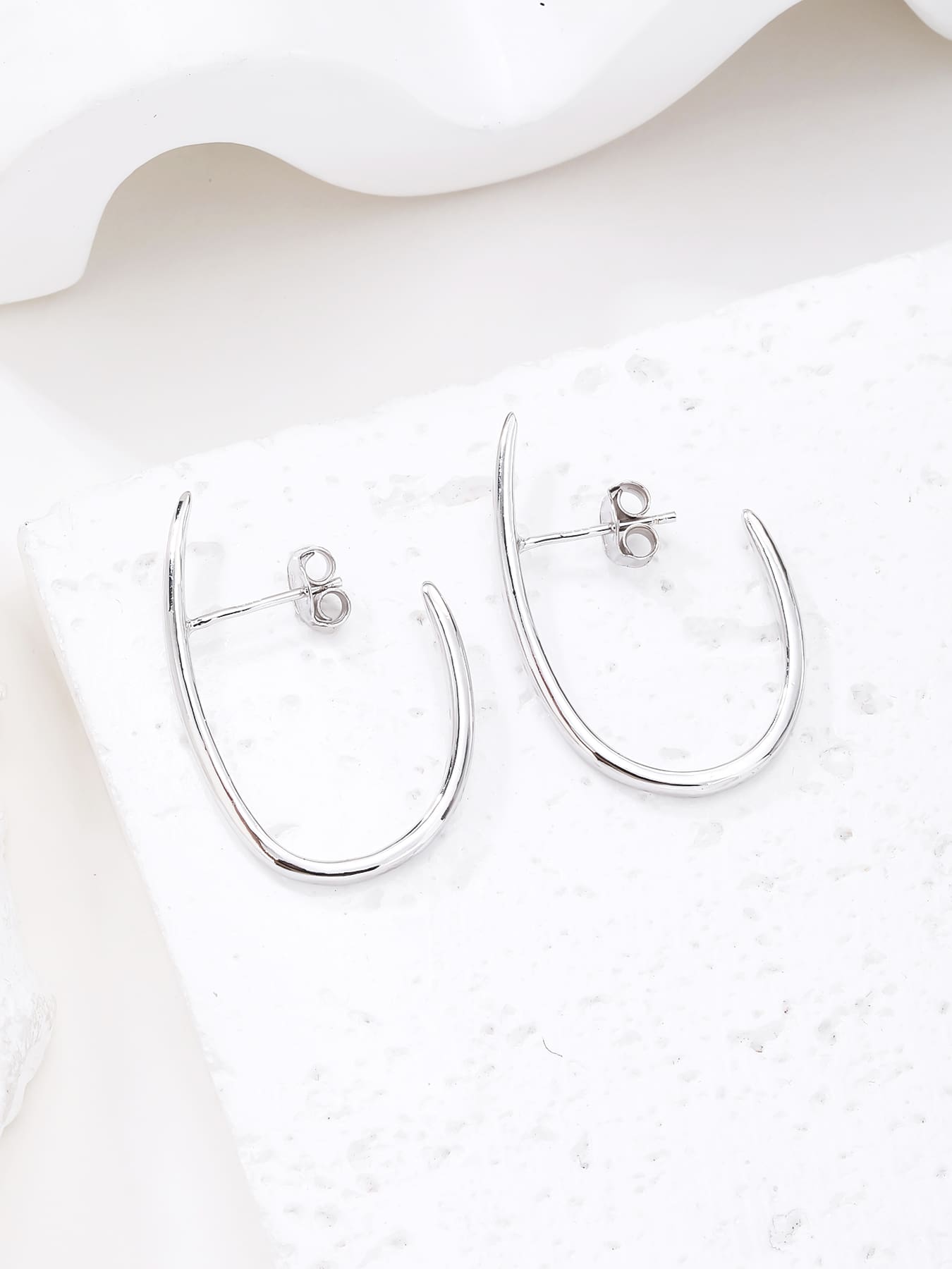 Curved minimalist stud earrings in hallmarked, rhodium-plated 925 sterling silver – lifestyle view – DRESCHER Jewellery®