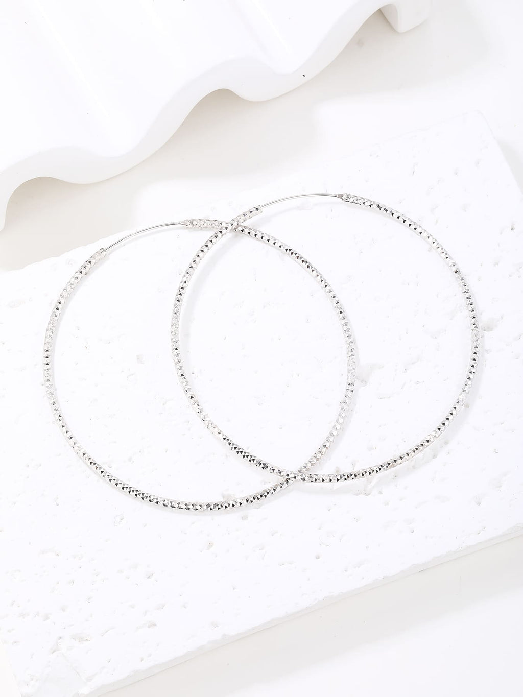 Large diamond-cut hoop earrings in hallmarked, rhodium-plated 925 sterling silver – display view – DRESCHER Jewellery®