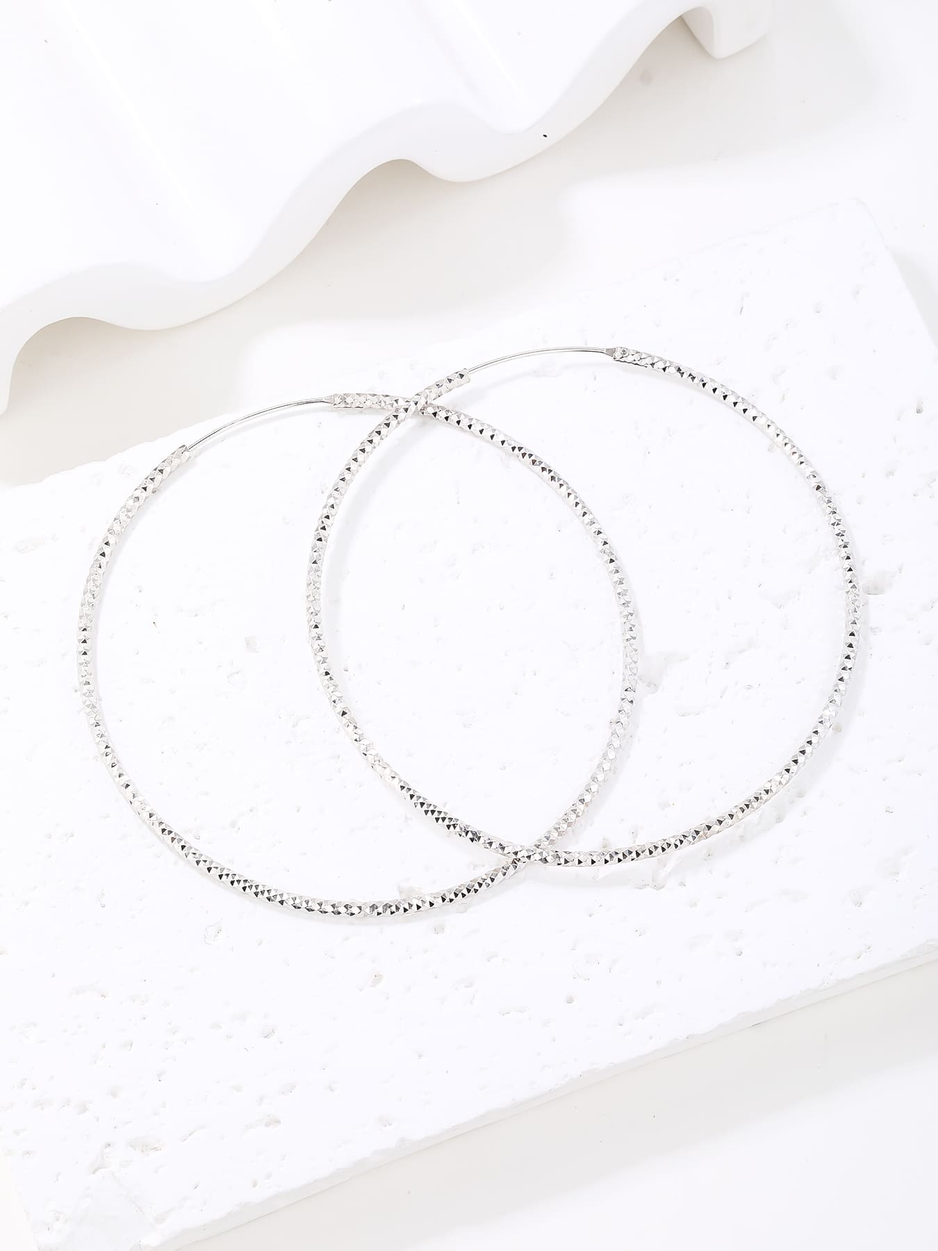 Large diamond-cut hoop earrings in hallmarked, rhodium-plated 925 sterling silver – display view – DRESCHER Jewellery®